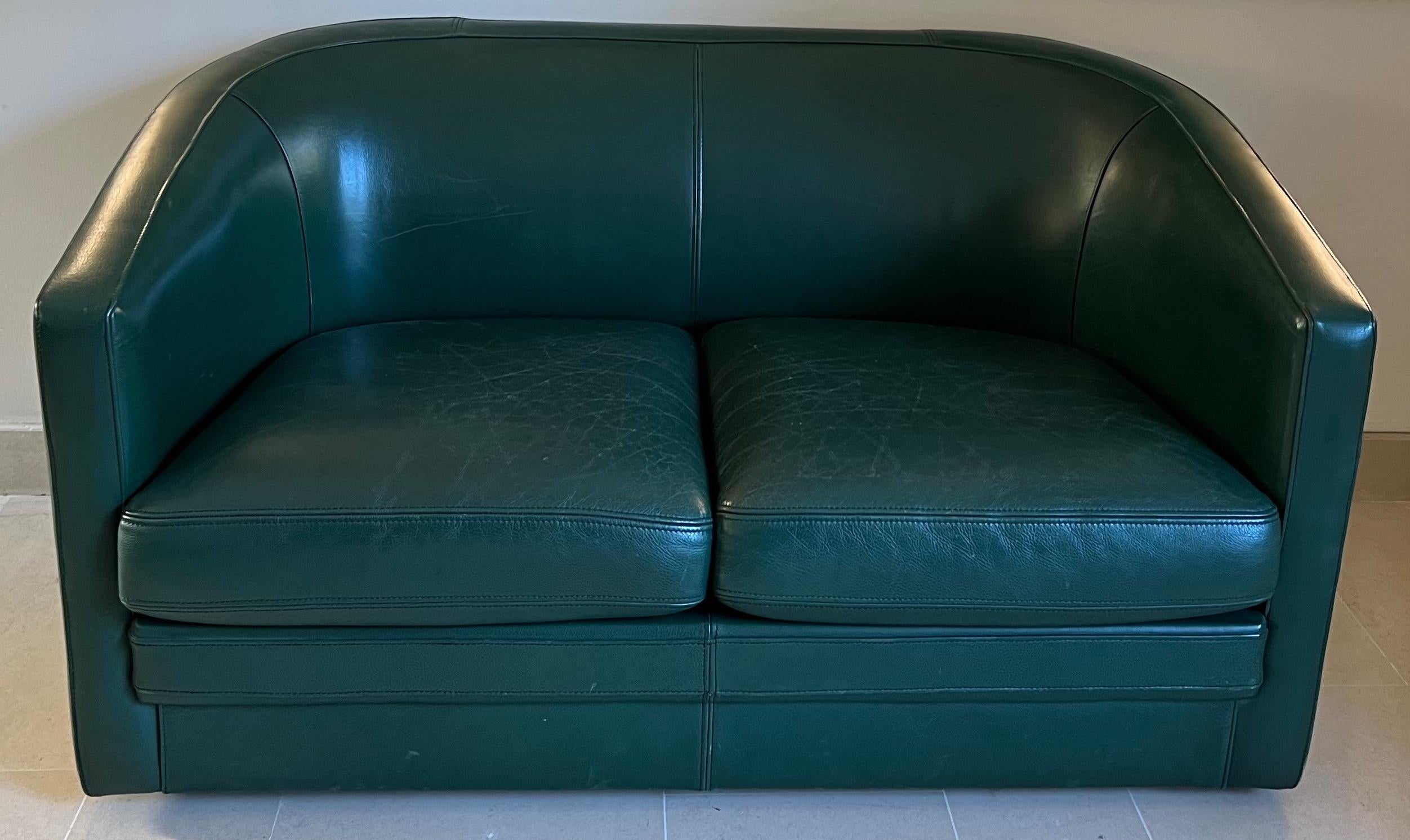 Ce canapé deux places est en cuir vert foncé. Il s'agit d'une œuvre française de style art déco. Circa 1980. Ce fauteuil peut être vendu séparément mais fait partie d'un ensemble comprenant un Canapé 3 places et un fauteuil club pivotant du même
