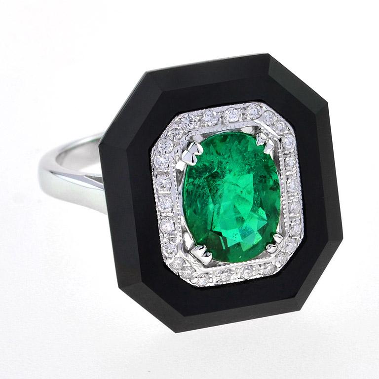 A striking and intriguing jewel, indeed. This big, bold, and colorful Art Deco style ring highlights a gorgeous gleaming emerald center stone, framed in a sparkling octagonal halo of round brilliant-cut diamonds, all set off with eye-catching