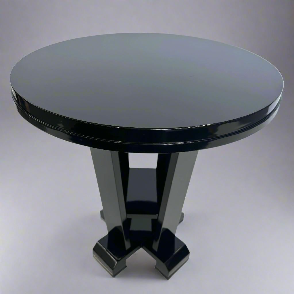 Guéridon de style Art Déco. Finition laquée noire sur quatre pieds avec étagère centrale. Fin du 20e siècle.  Les pieds sont dotés de capuchons chromés.