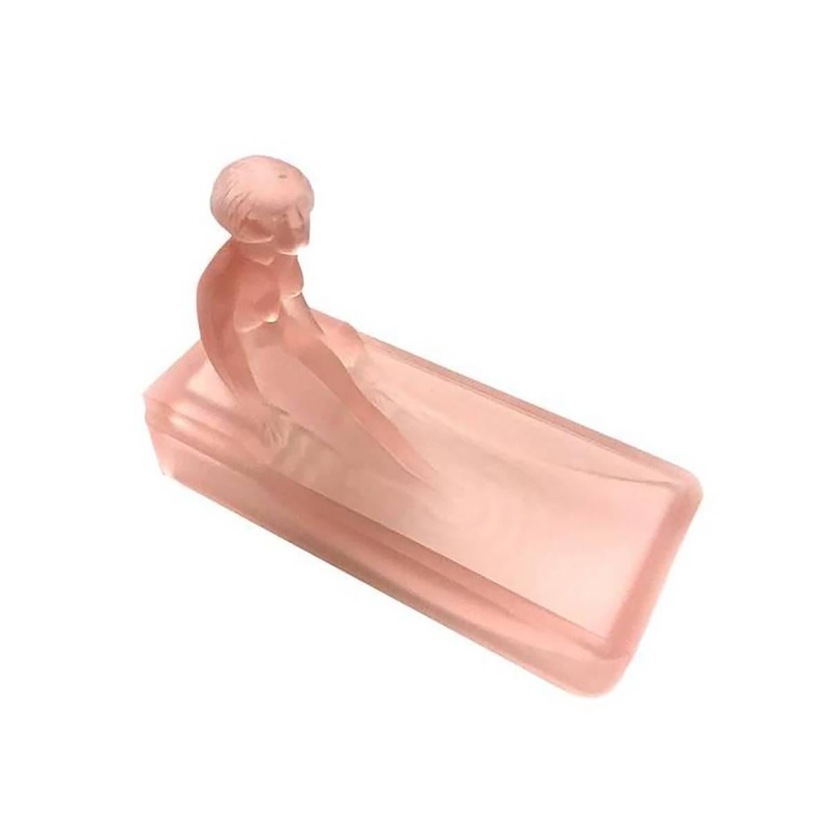 This 1970s re-edition of a 1927 Art Deco Heinrich Hoffman pink art glass soap dish/ring tray features a nude female figure bathing in a tub.

Condition: Excellent.
Specifications: Height 2.75, width 6, depth 4.
Materials /techniques: