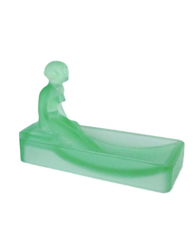 This 1970s re-edition of a 1927 Art Deco Heinrich Hoffman frosted green art glass soap dish/ring tray features a nude female figure bathing in a tub.

Condition: Excellent.

Specifications: Height 2.75, width 6, depth 4.

Materials/techniques: Glass.
