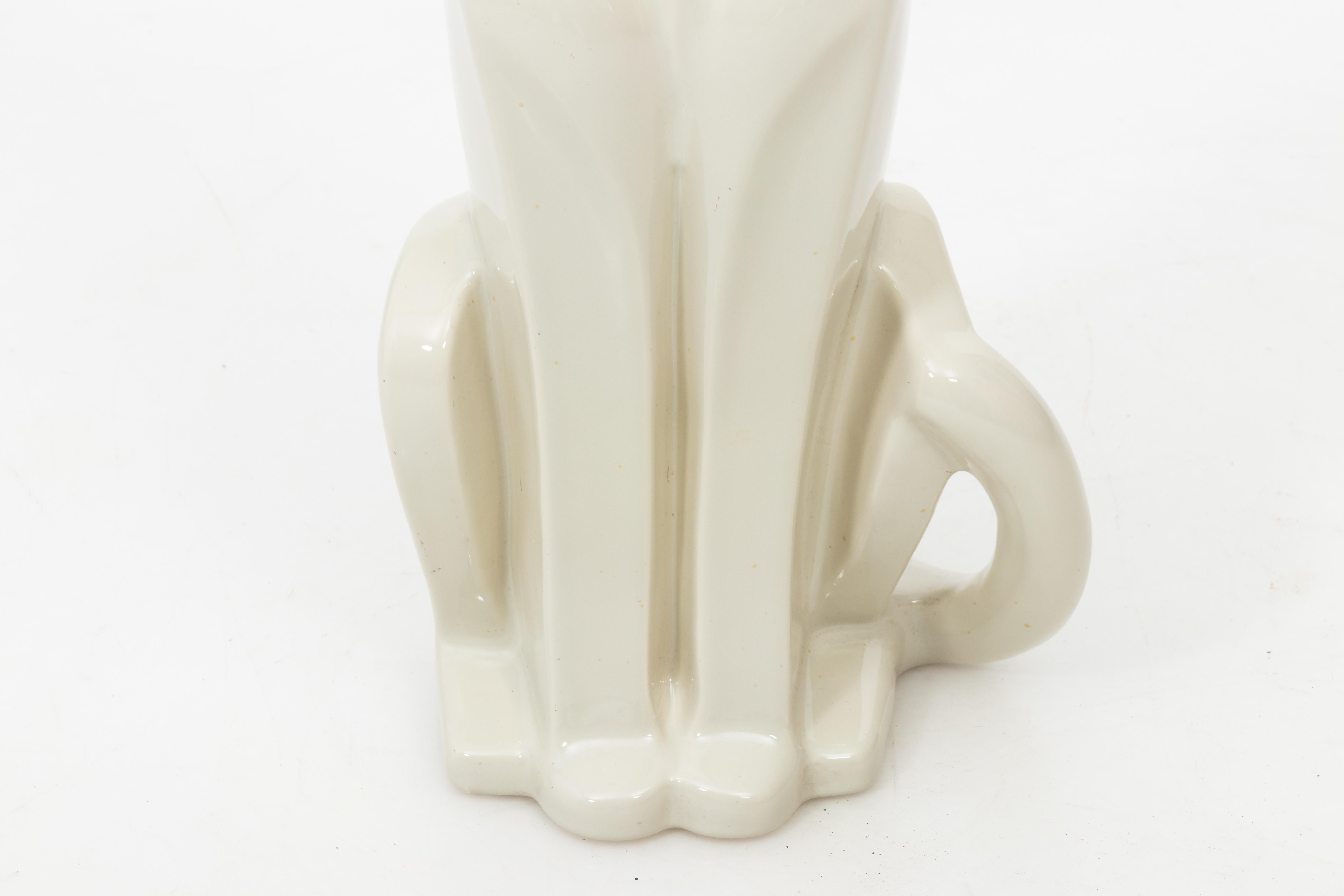 A ceramic sculpture of a seated panther in white/ off-white, made by Haeger in the in the United States. The piece is made in an Art Deco style and includes the original label on the bottom. In very good vintage condition.