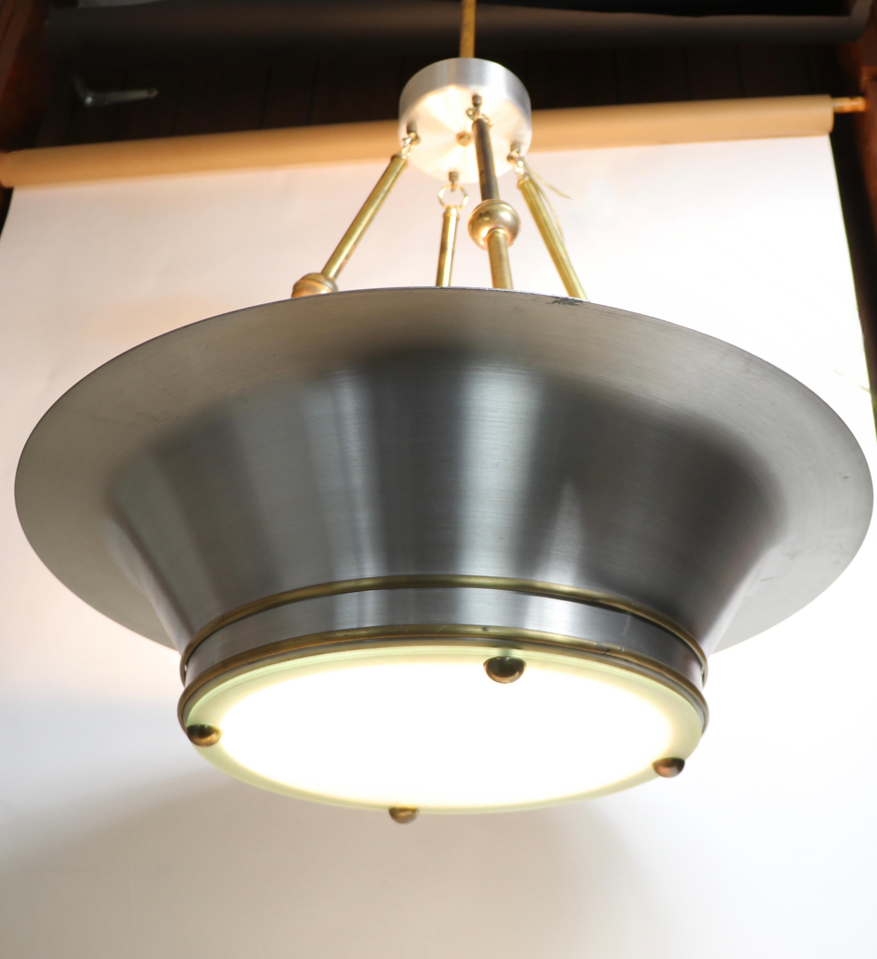Large and impressive spun aluminum, frosted glass, and brass chandelier, in the Machine Age, Hollywood Regency, Art Deco style, made in the USA circa 1980's. 
 The circular aluminum fixture measures 31 inch in diameter x 17 inch height without the