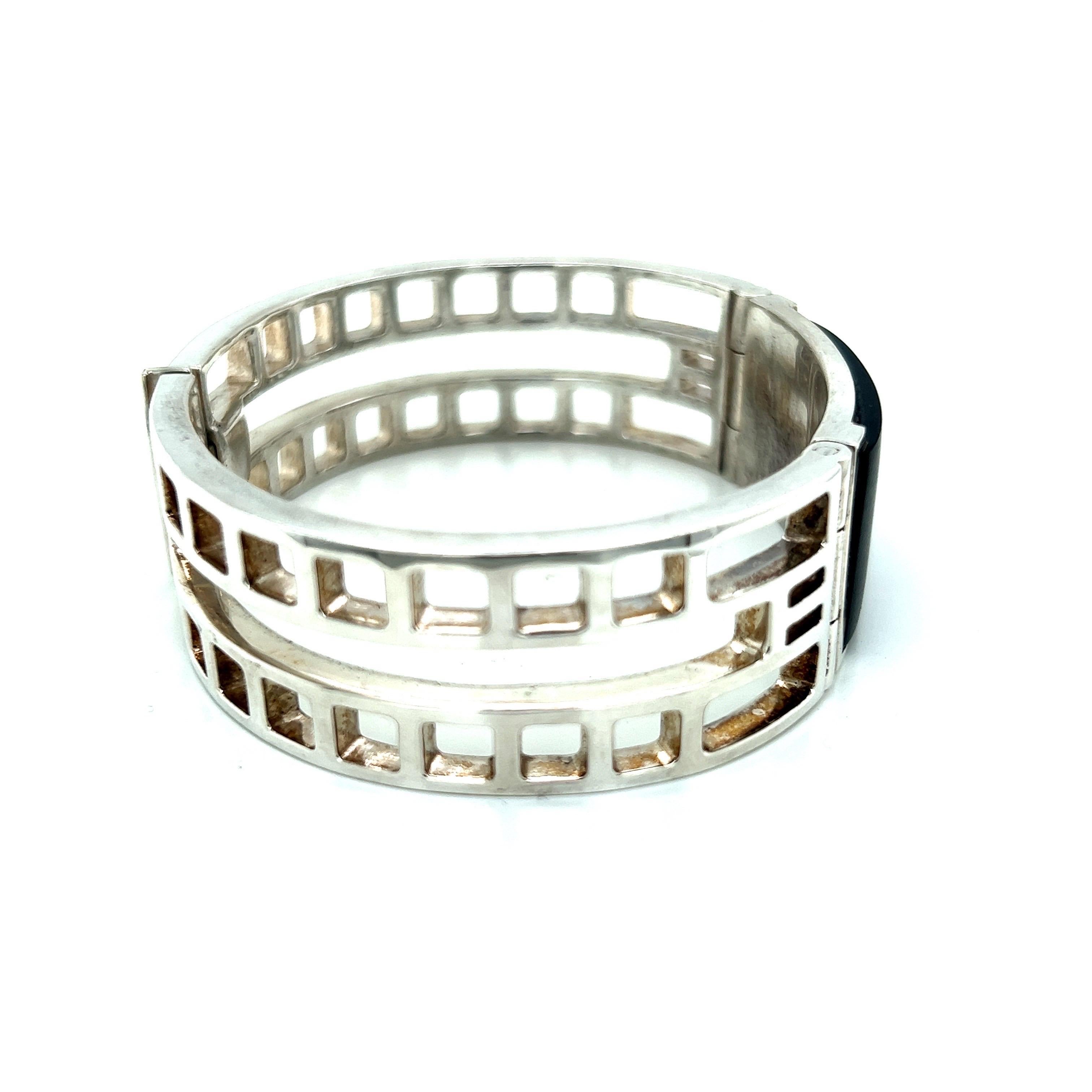 This Art Deco design bracelet is a true work of art, with a striking graphic cut-out pattern that creates a bold and modern look. The bracelet features a matte finish black onyx ID plate set in a polished metal frame, adding a touch of elegance to