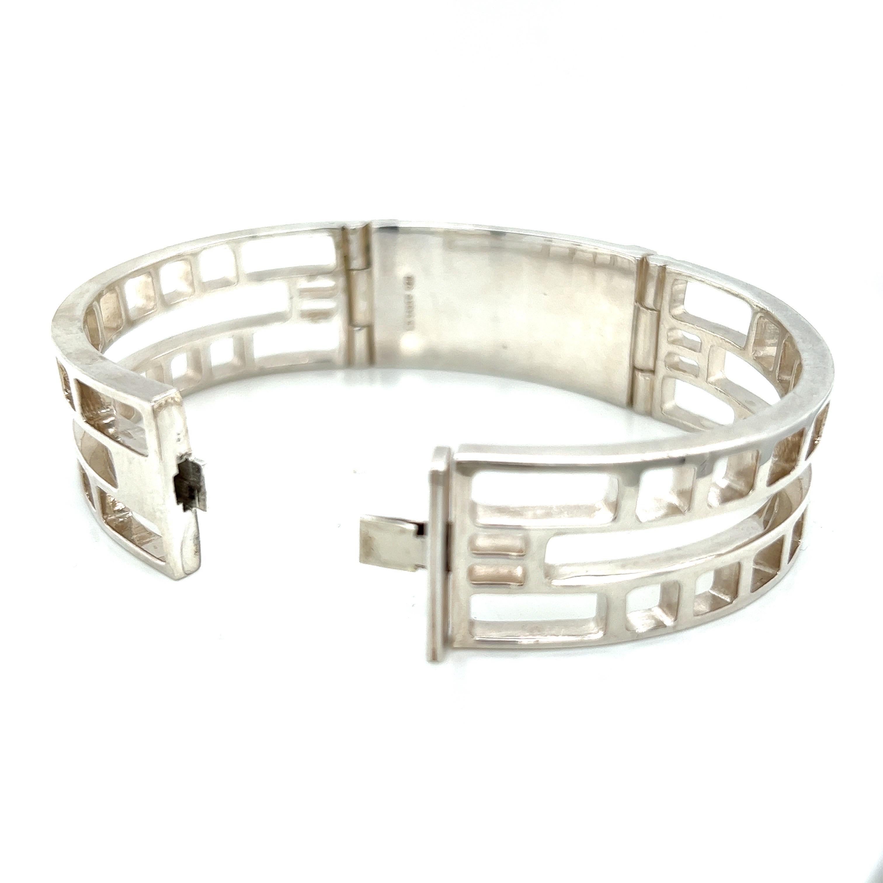 This Art Deco design bracelet is a true work of art, with a striking graphic cut-out pattern that creates a bold and modern look. The bracelet features a high polish hand-cut hematite ID plate set in a polished metal frame, adding a touch of