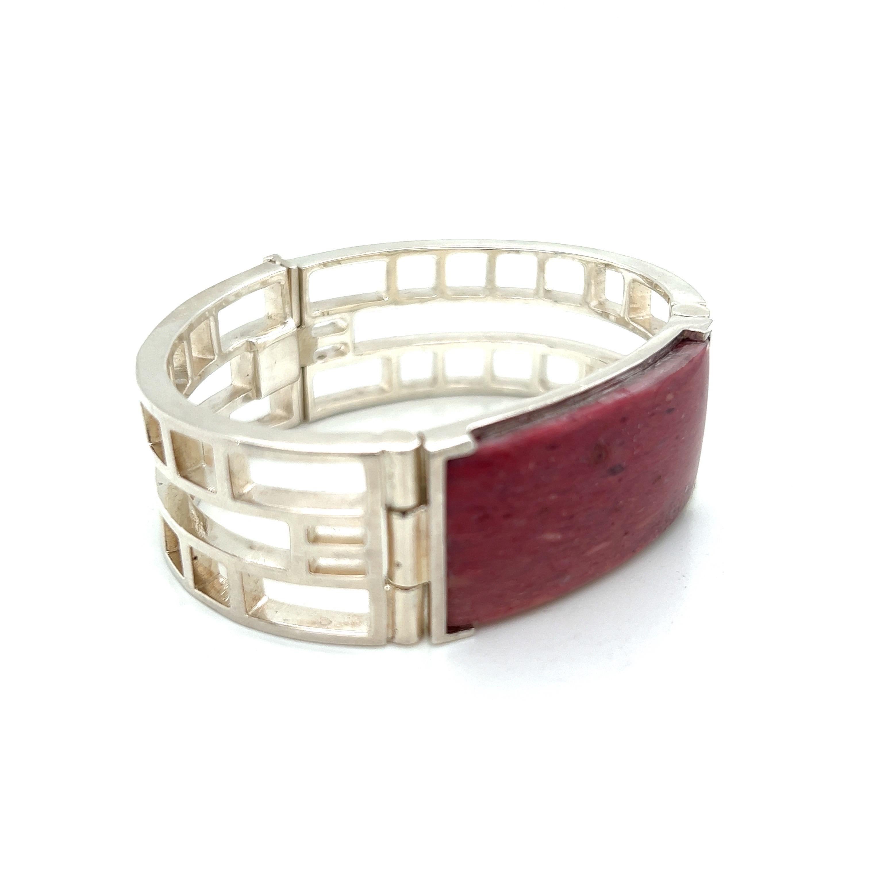 This Art Deco design bracelet is a true work of art, with a striking graphic cut-out pattern that creates a bold and modern look. The bracelet features a high polish hand-cut strawberry quartz ID plate set in a polished metal frame, adding a touch