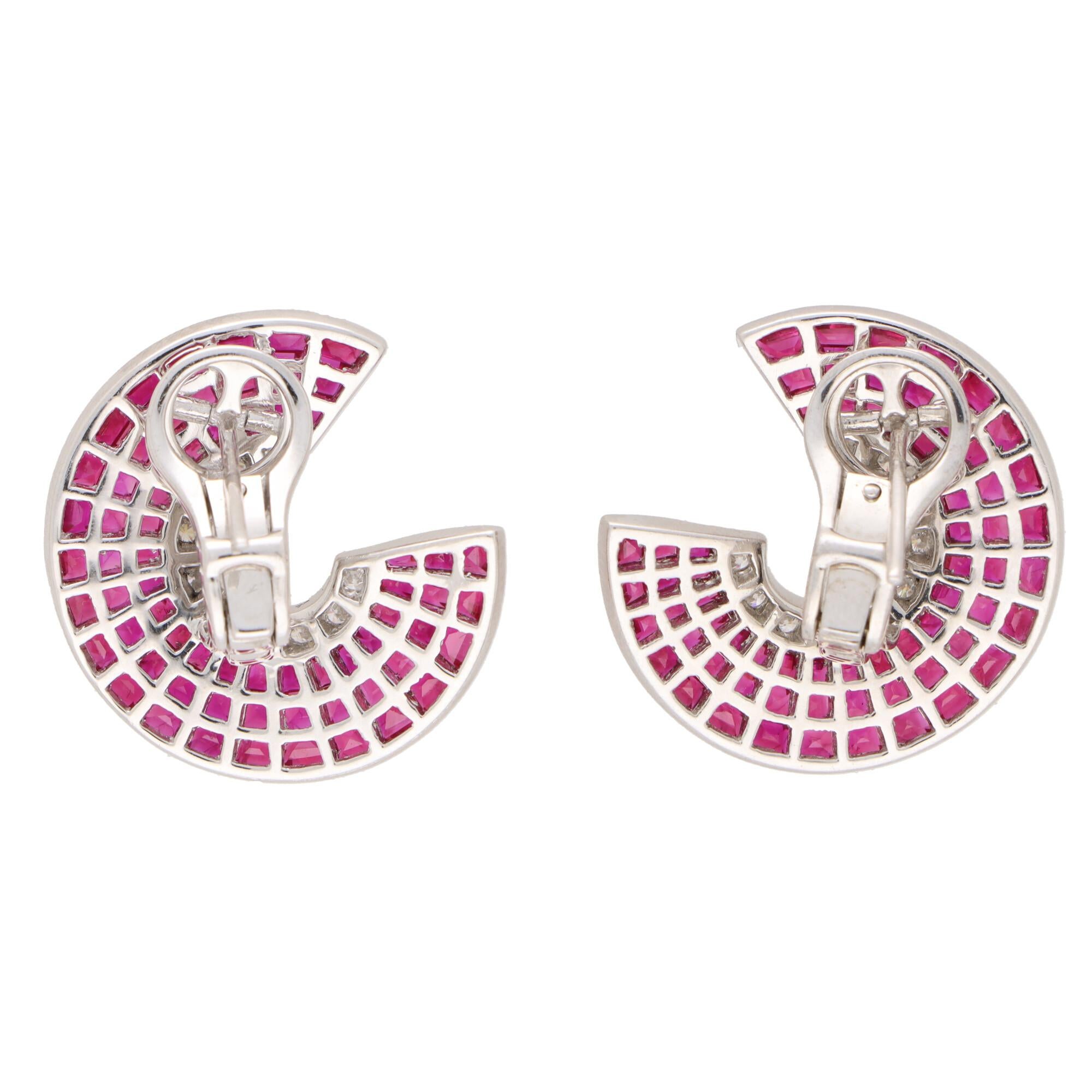  A beautiful pair of Art Deco inspired diamond and ruby swirl half hooped earrings set in platinum.

Each earring is composed of swirl design, designed to curve around the ear quite like a half hoop. The earrings are predominantly set with a panel
