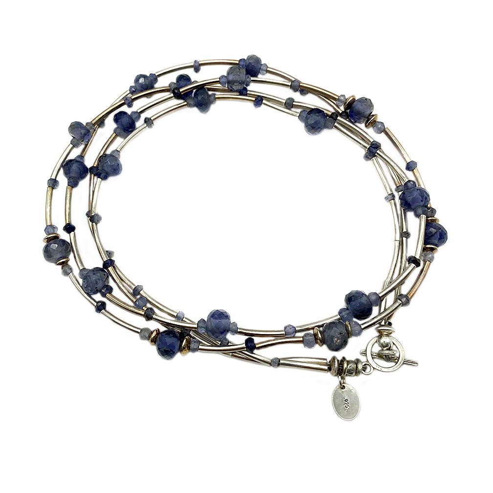 This is an Art Deco style iolite and sterling necklace. This double strand necklace was created with high grade 10 mm and 3 mm faceted translucent Iolite rondelle gemstone beads and sterling silver 10 mm curved tubes. It ends with a small sterling