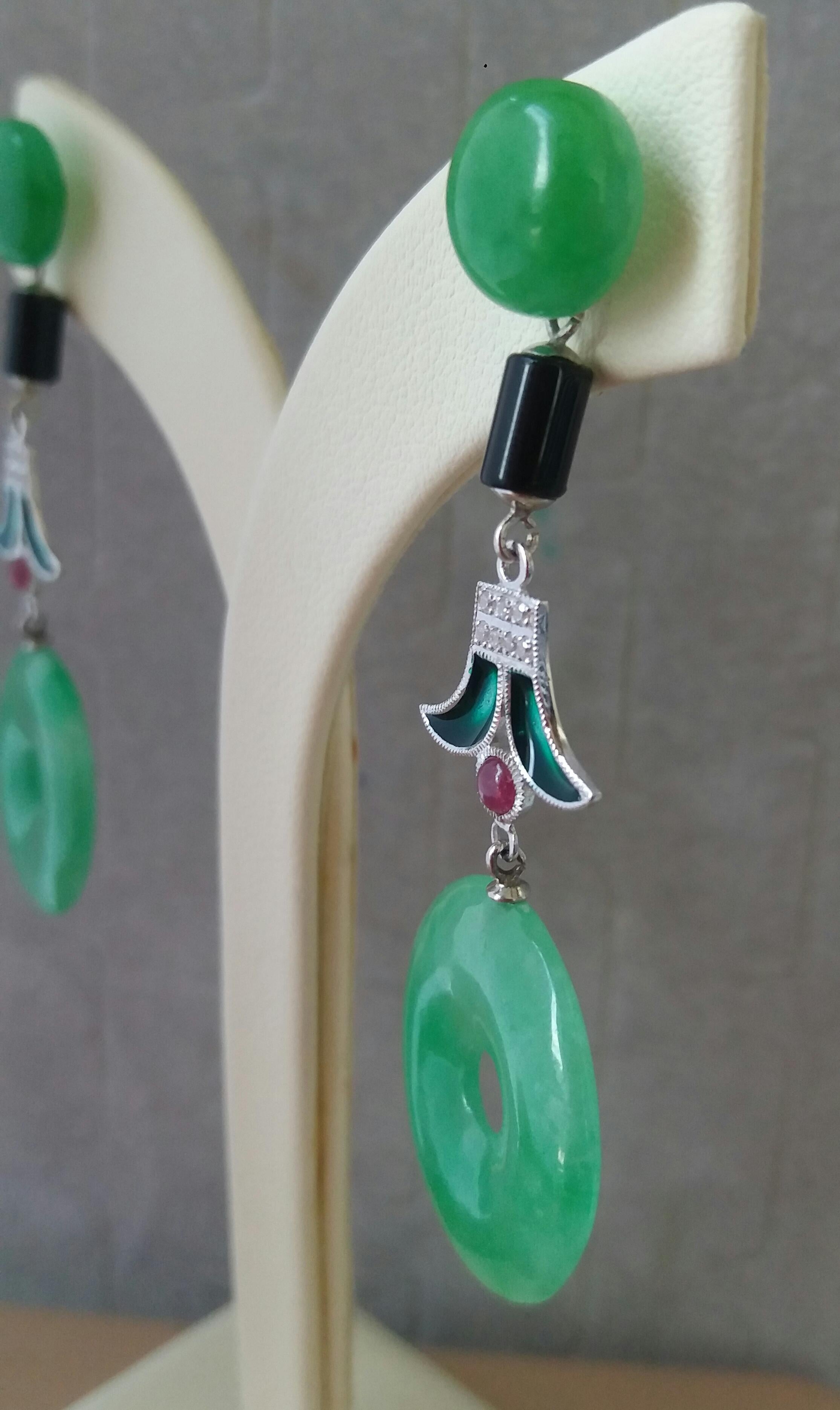 Nella parte superiore abbiamo 2 bottoni rotondi di giada, la parte centrale è composta da 2 piccoli cilindri in onice nera, 2 elementi in oro bianco, diamanti, piccoli rubini cabochon e smalto verde mentre nella parte inferiore abbiamo 2 ciambelle