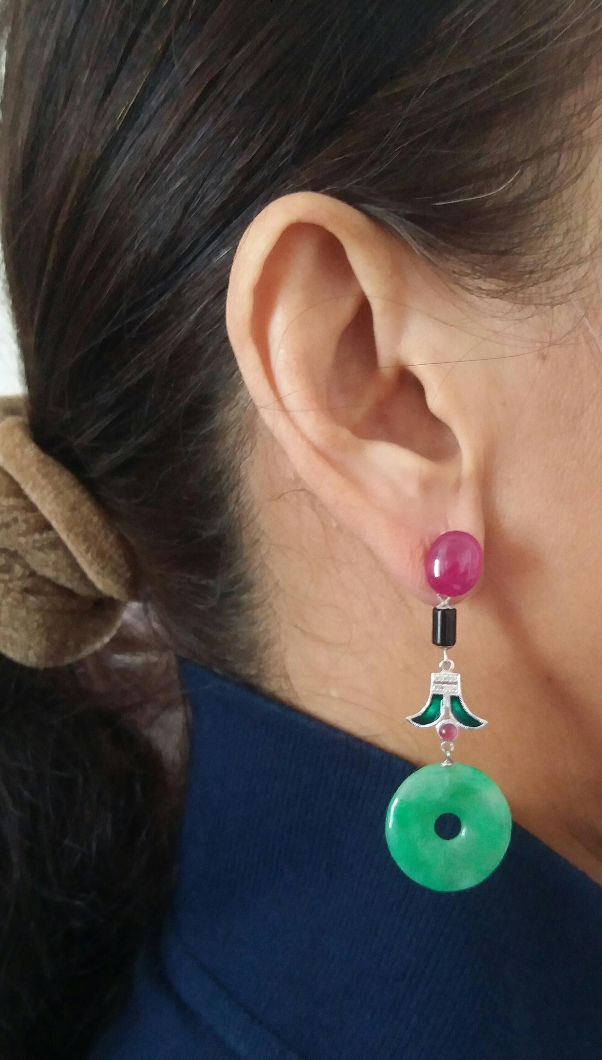 Abbiamo 2 grandi rubini cabochon che compongono la parte superiore, una parte centrale con 2 piccoli cilindri in onice nera, 2 elementi in oro bianco, diamanti, smalto verde e 2 piccoli rubini cabochon, nella parte inferiore ci sono 2 dischi di