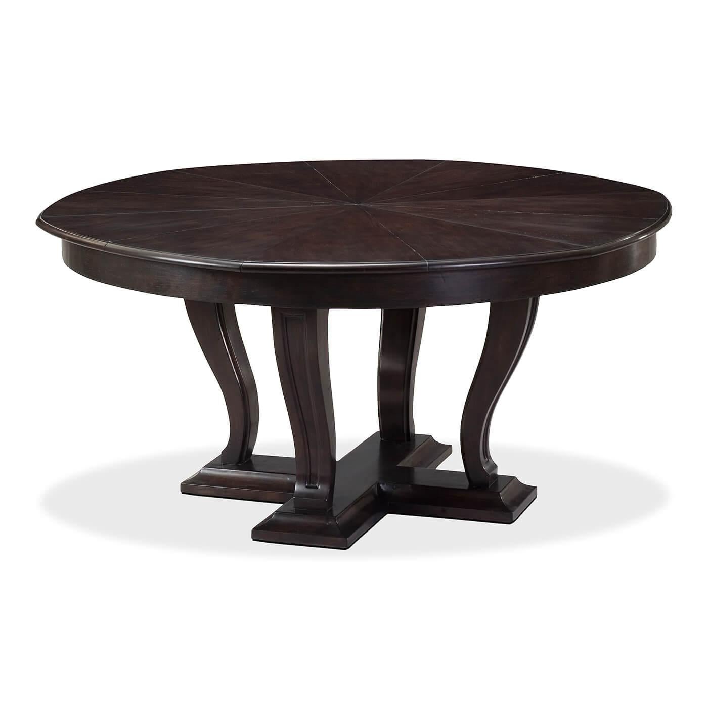Art Deco Style dining table on a transitional styled base consisting of tapered serpentine curved legs that have been carved with an inset panel design. They sit on a platform base that has been framed with a bold cove shape. The top is radial