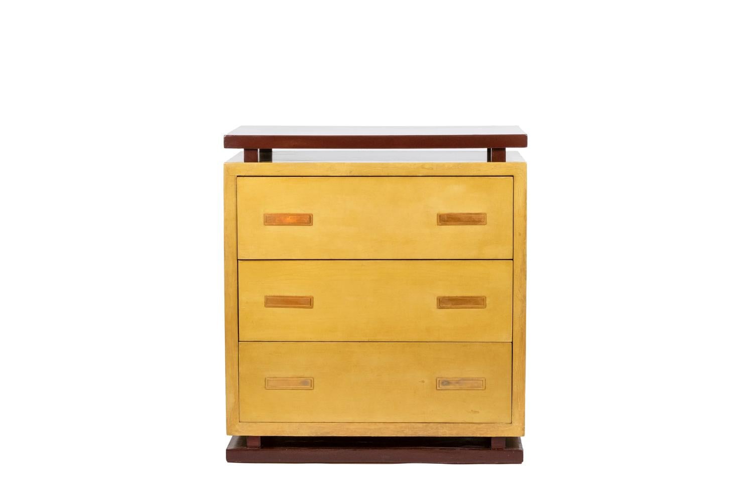 Chest of drawers in Art Deco style in cream-coloured lacquer, opening with three drawers in front. Top and base in burgundy color. Brass handles with a pusher to hold the handle in the hand, rectangular in shape.

Work of a French decorator from