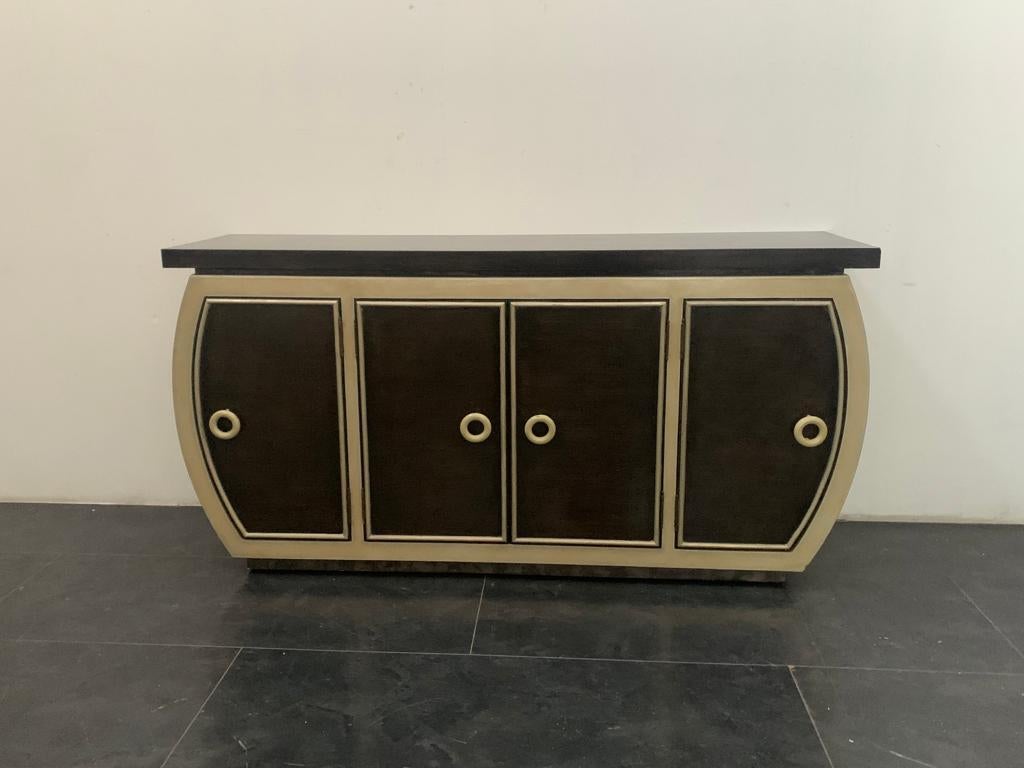 Lam Lee Group
Art Deco style sideboard made in the 1990s and produced by Lam Lee Group. It is characterised by rounded sides and a generously thick top, the body is sponge lacquered on metal leaf, the doors and top are lacquered and finished in
