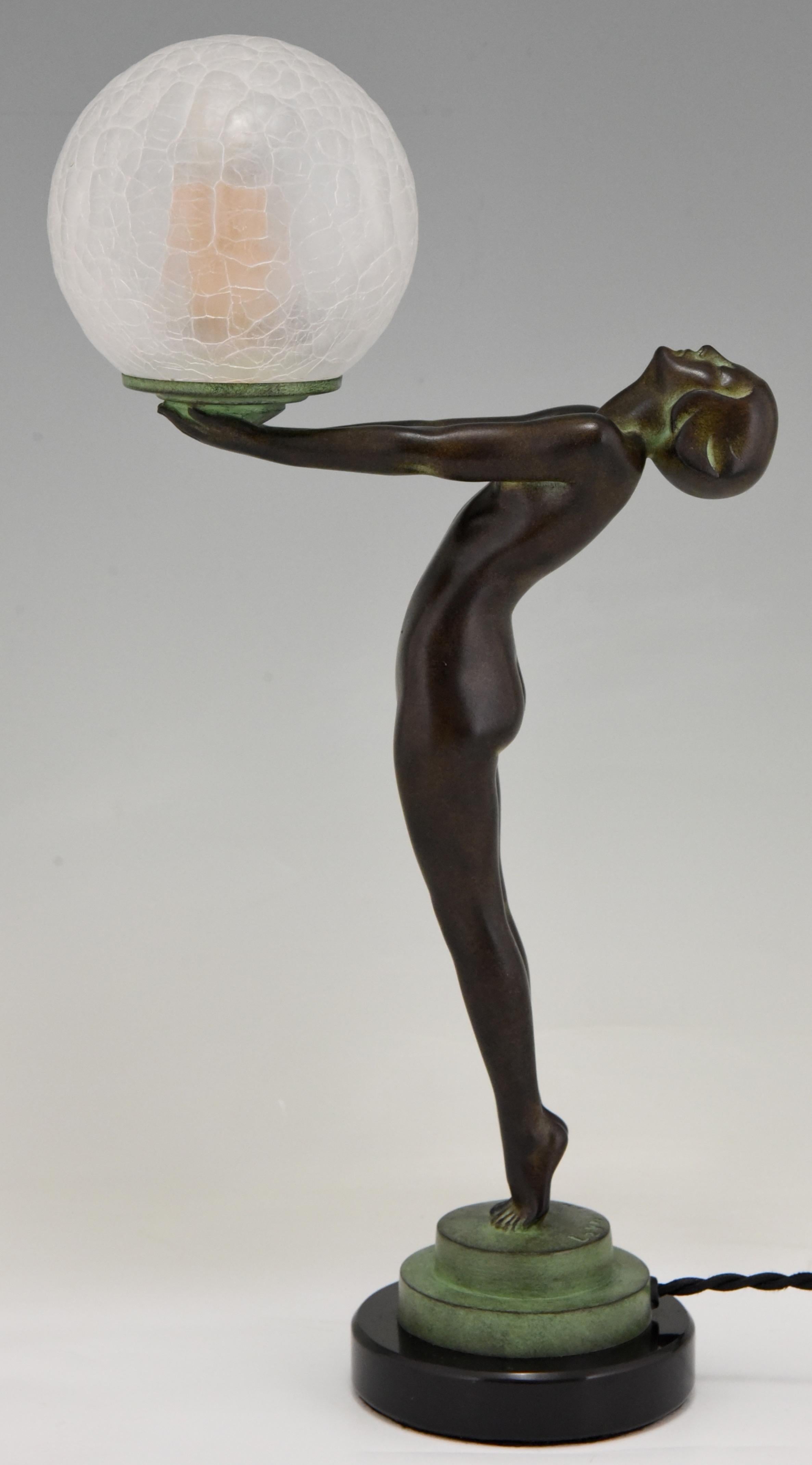 Lampe de table figurative de style Art Déco représentant une femme nue debout tenant un globe en verre.
Ce modèle, appelé Lueur lumineuse, est la version réduite de l'emblématique lampe Calle de Max Le Verrier.
La lampe est signée et porte la marque