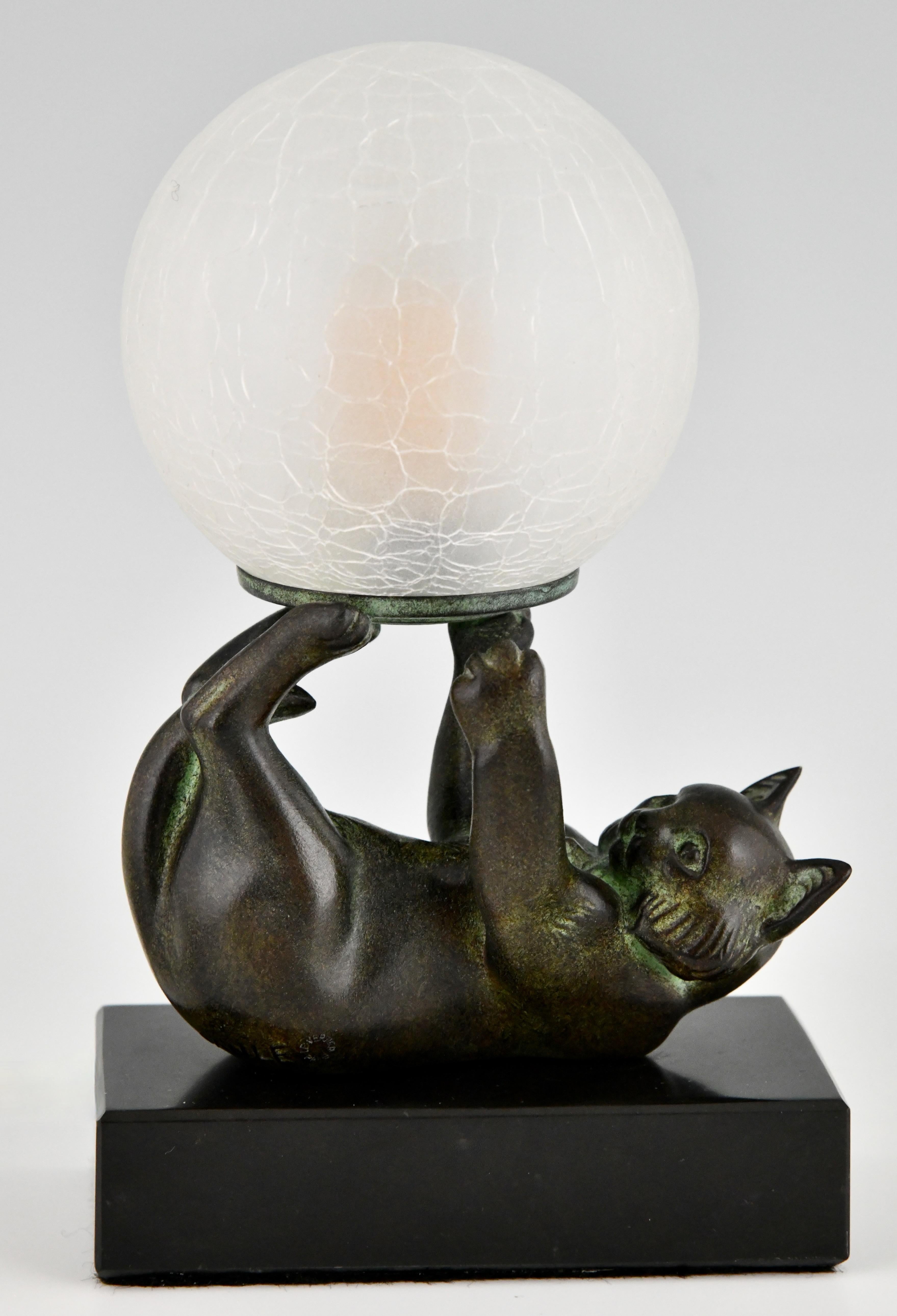 Art Deco style lamp with cat CHAT JONGLEUR signed Janle for Max Le Verrier. 
With Max Le Verrier foundry seal. 
Design 1930. Posthumous contemporary cast. 
Patinated Art Metal on a black marble base with glass shade. 
US plug will be provided for
