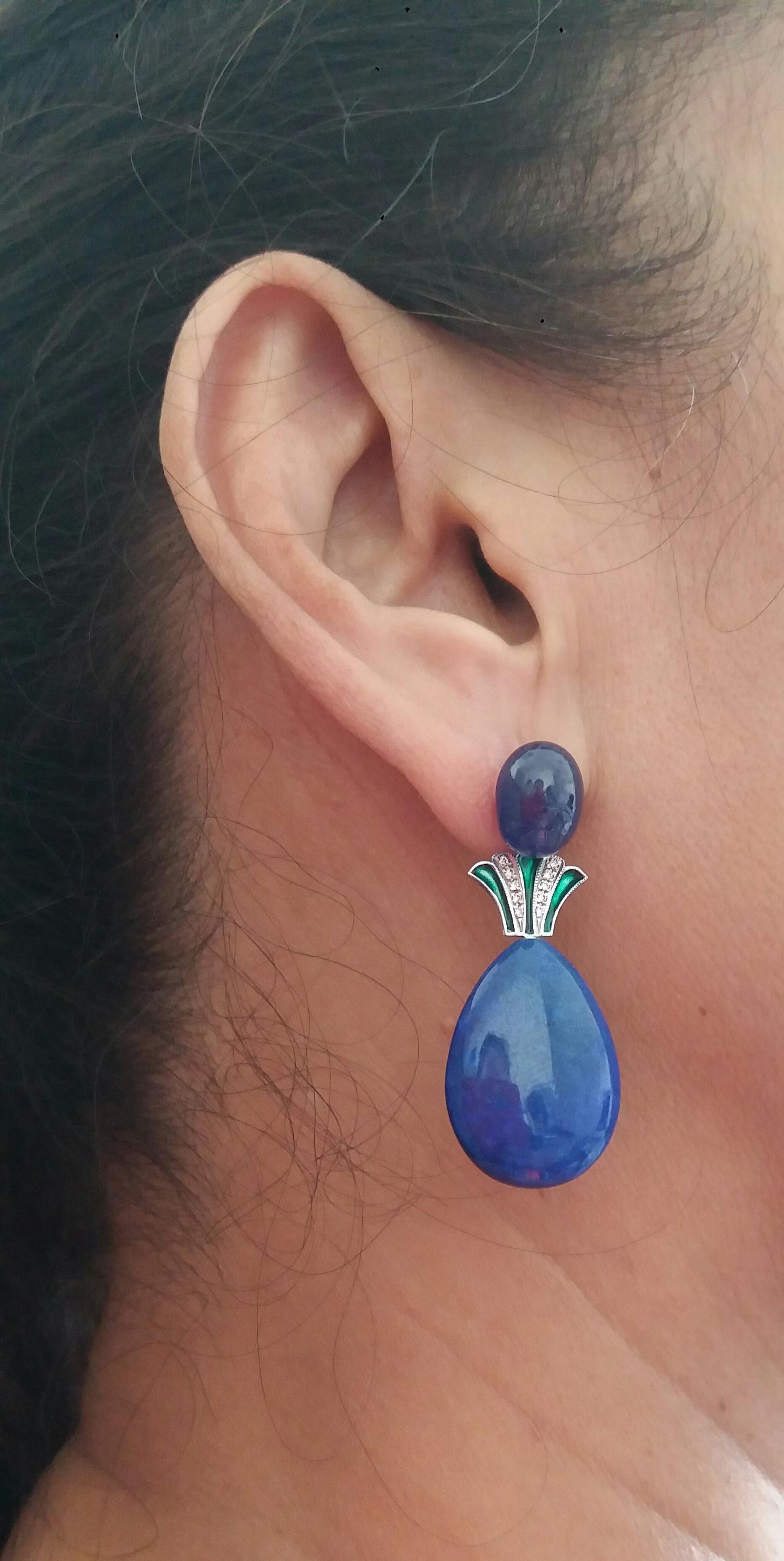 2 large blue sapphire oval cabs (9x12 mm) are the top, then the middle part is in white gold,20 small full cut  diamonds and green enamel, the bottom is composed of 2 flat drops in natural Lapis Lazuli measuring 18 x 25 mm
In 1978 our workshop