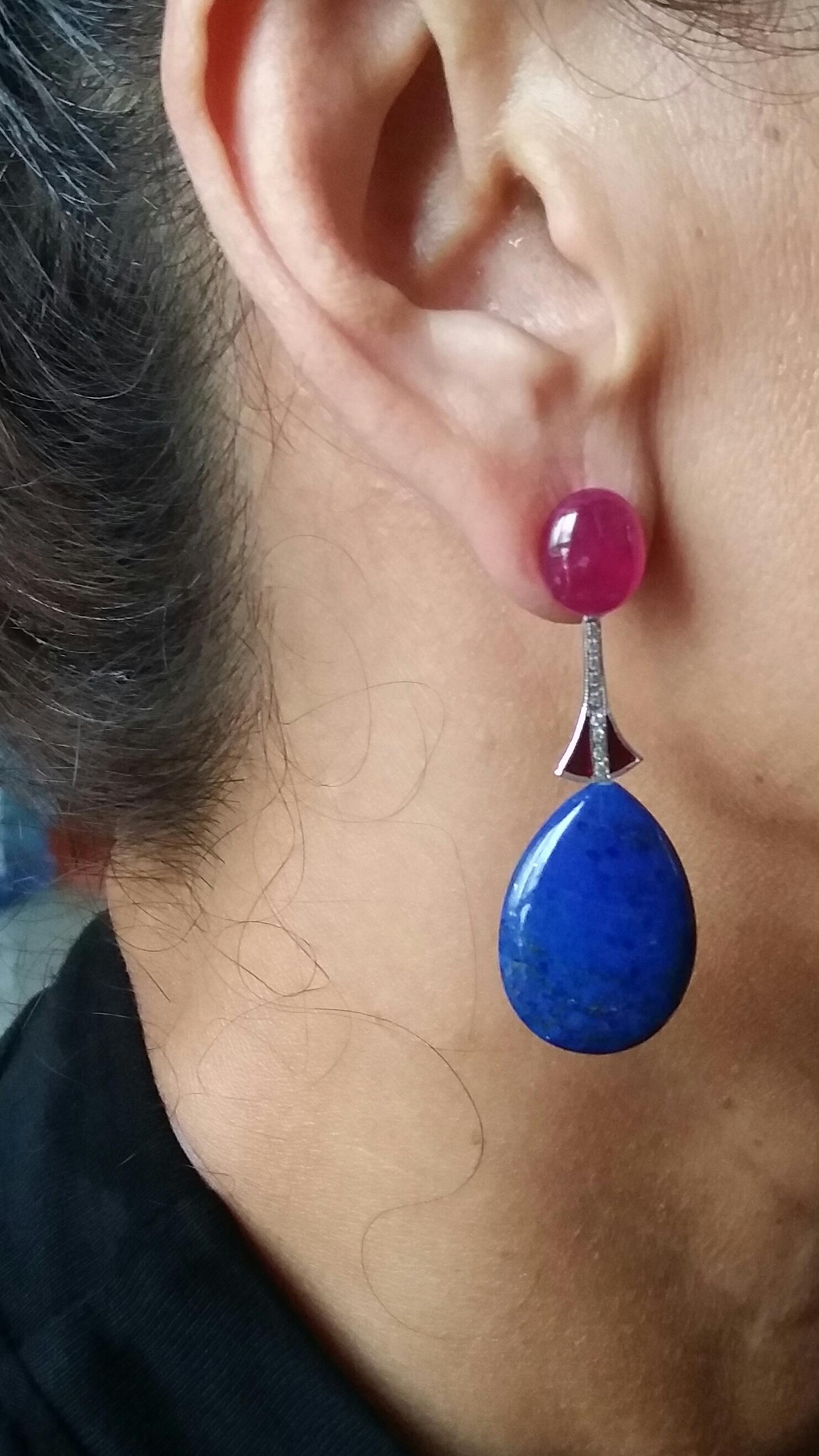 2 large oval Ruby cabochons support 2 white gold elements, diamonds and red enamel, at the bottom we have 2 drops of  natural Lapis Lazuli .
In 1978 our workshop started in Italy to make simple-chic Art Deco style jewellery, completely handmade and