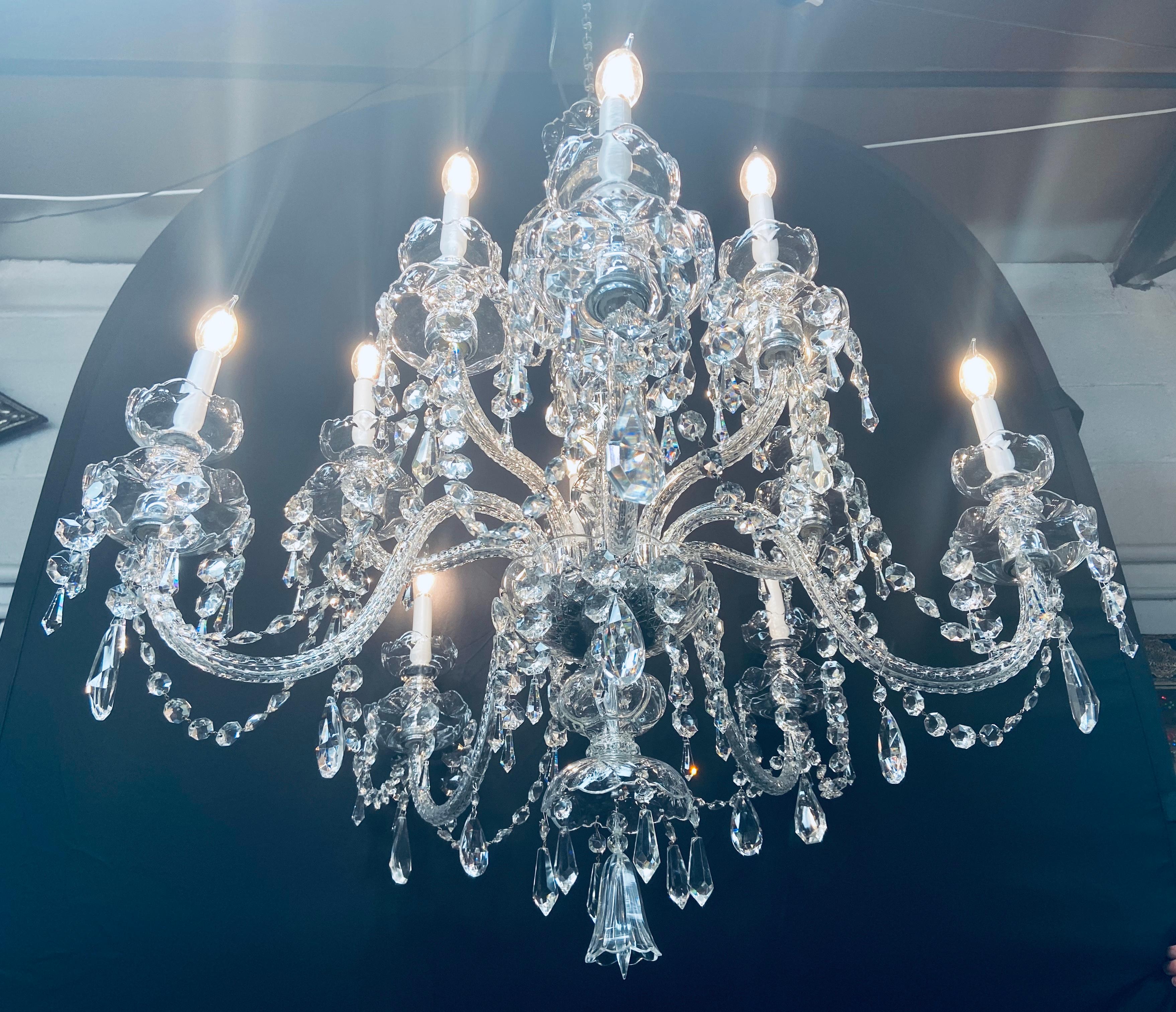 Un magnifique lustre en cristal de grande taille à la manière de Waterford. Le lustre comporte 10 bras et accepte 10 ampoules candélabres. Les prismes de cristal finement taillés sont suspendus à un double goutte-à-goutte en forme de bobèche. Ce