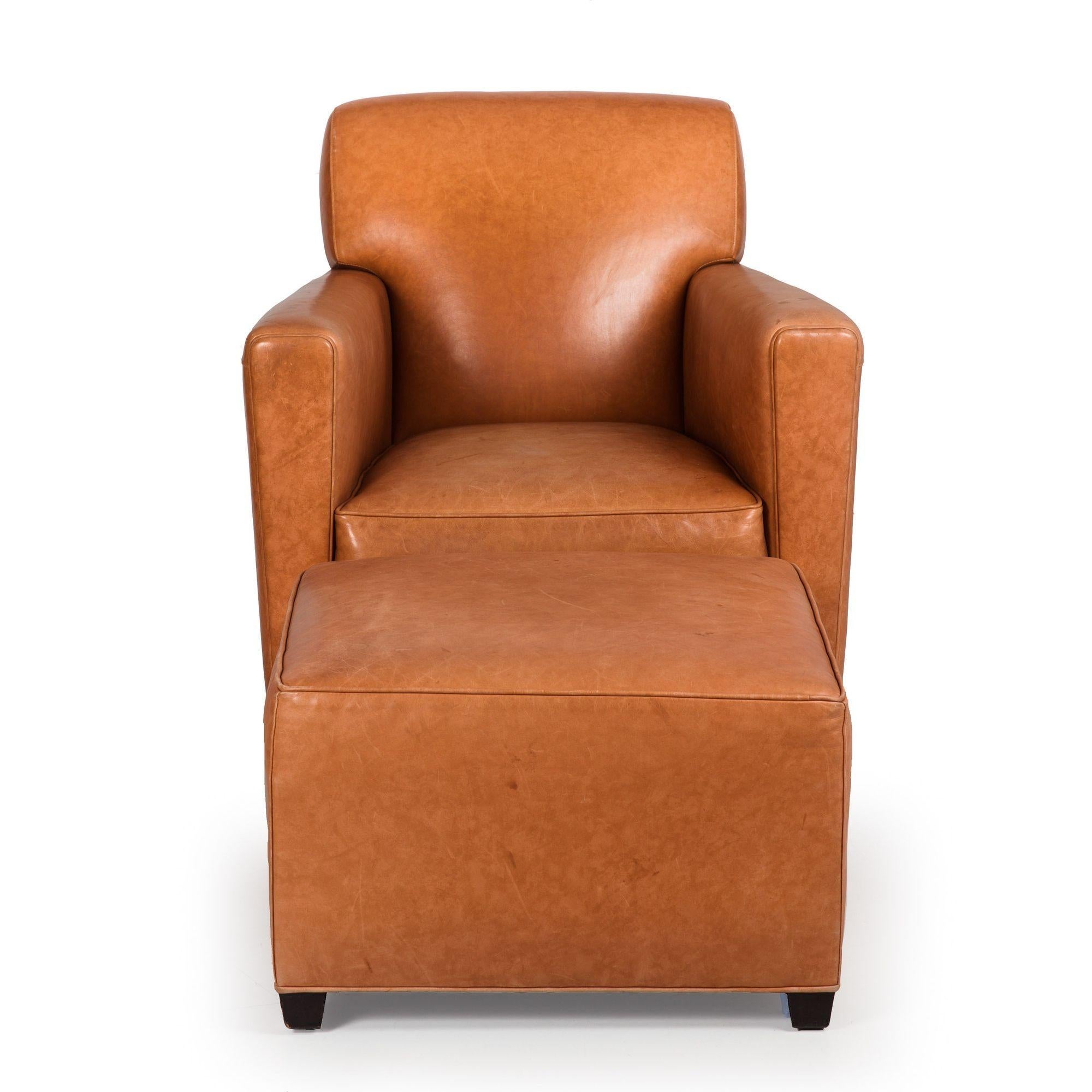 A very sleek club chair and matching ottoman designed with a nod to the elegance of the Art Deco era, the attached back and seat presenting a unified and crisply tailored appearance. The tight back rests on a generous cube seat, defined by slight
