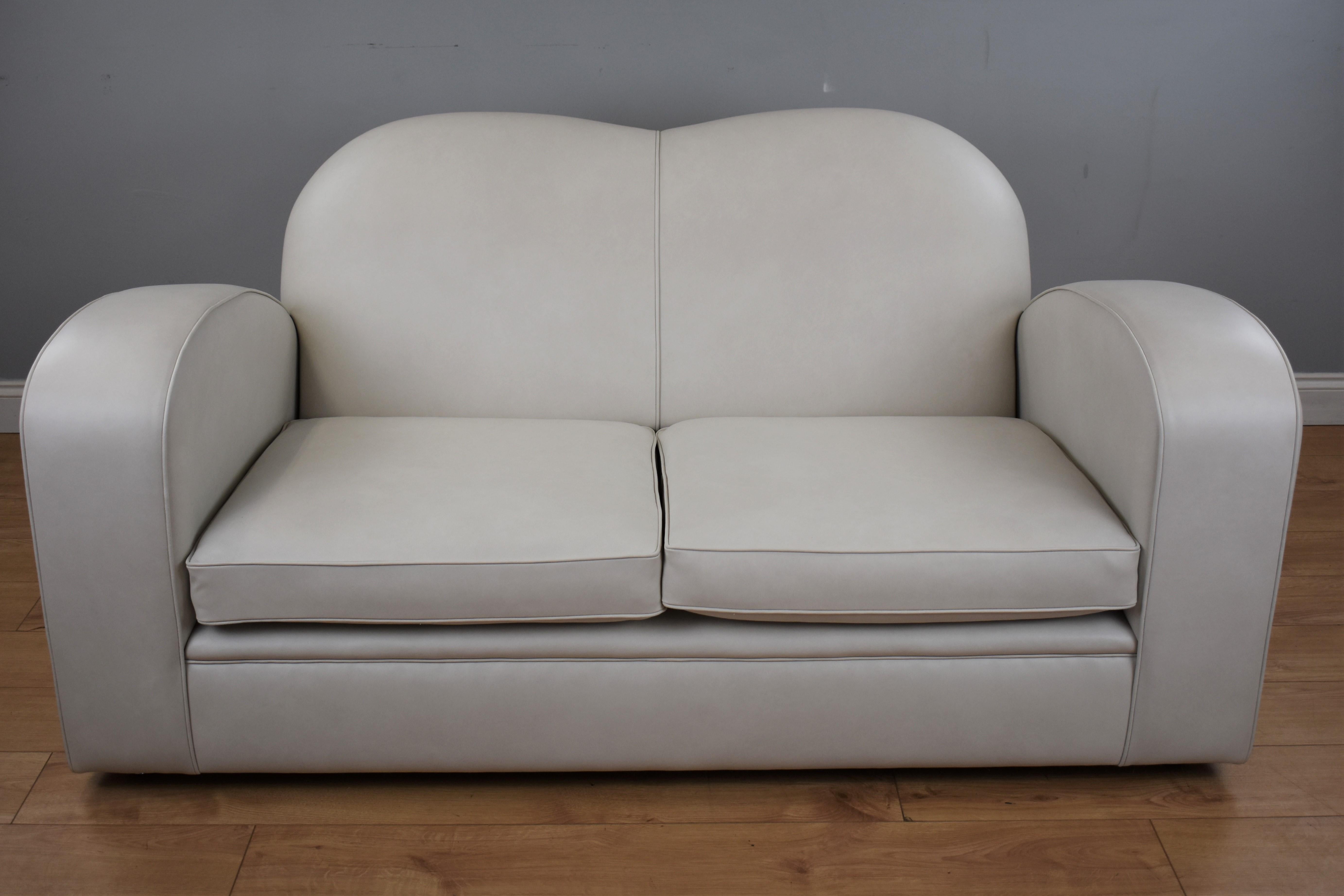 Art Deco two-seat sofa upholstered in a frost grey leather with matching piping to the edge.