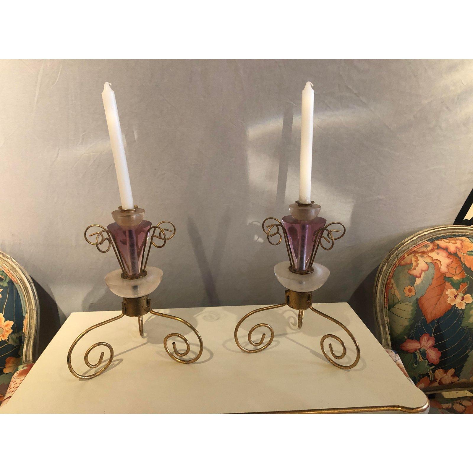 A gorgeous pair of Art Deco candlesticks. The candlesticks are made of Lucite and gilt metal and feature a lovely pink or purple color that adds glamor and style to them.

Measures: 10