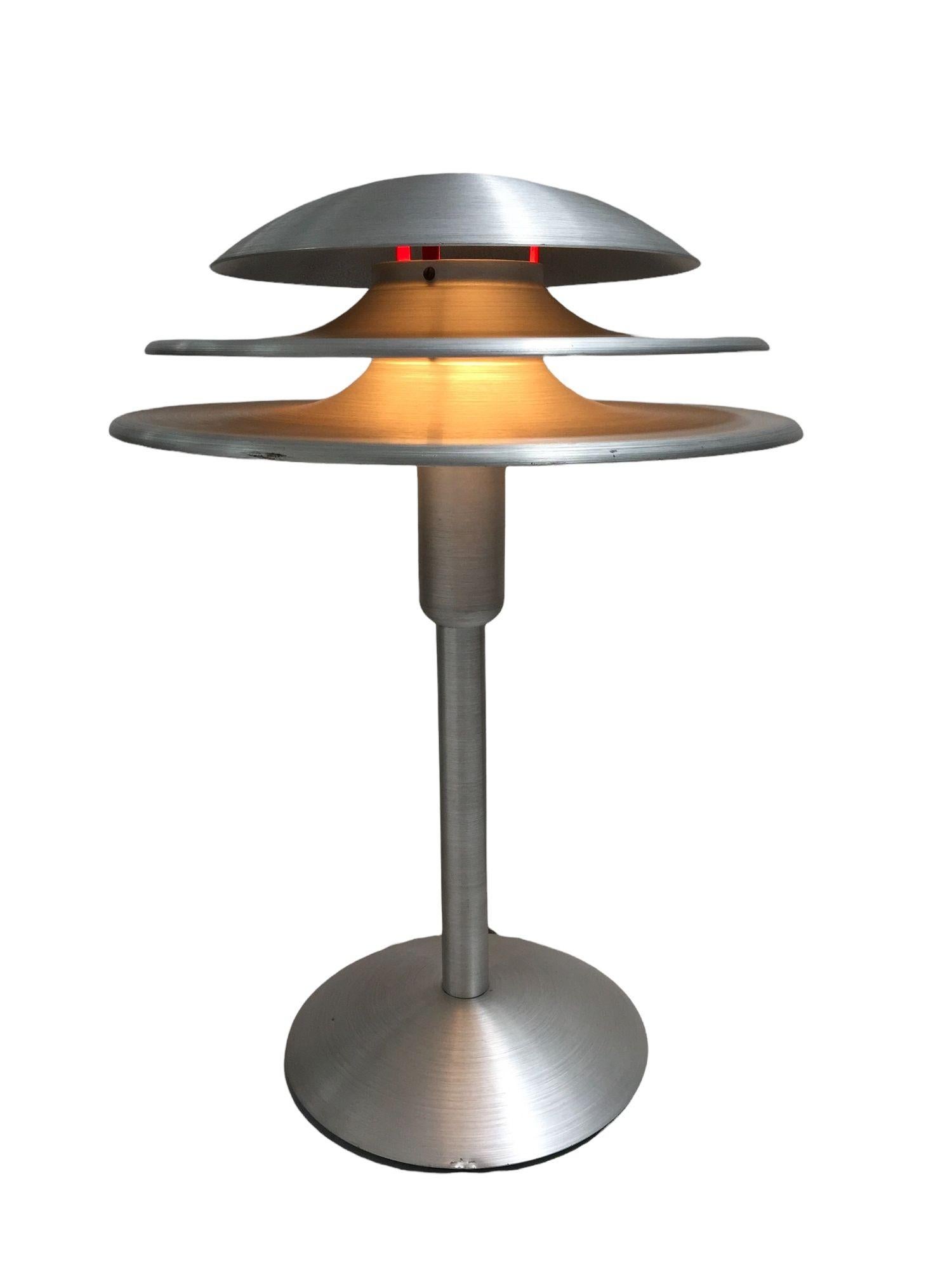 Art Deco Style machined and Brushed Aluminum Desk Lamp Features a 3-layered spun aluminum shade and a spun aluminum body. The surface has a nice brushed finish to them, making them a 1930s machined age look. They have a dimmable switch with 2 stops