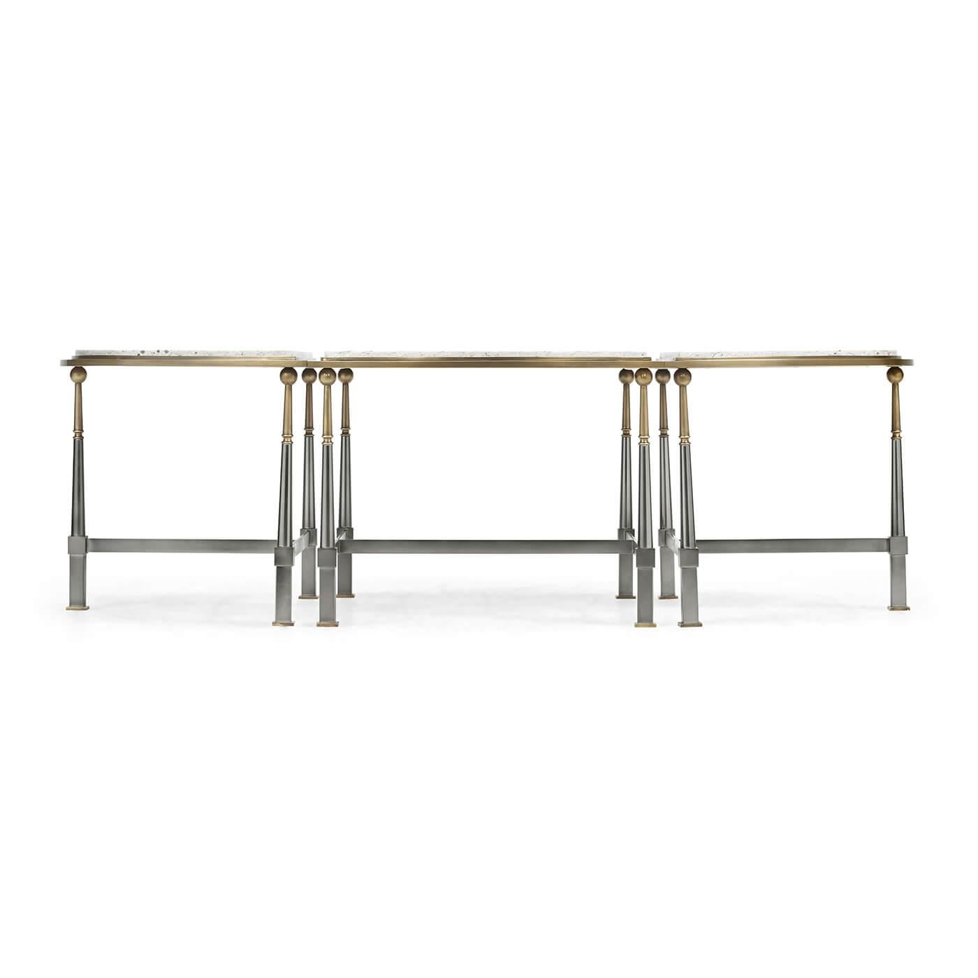 An Art Deco style cocktail table in the manner of Gilbert Poillerat. The three-part coffee table with a speckled white marble top, above a brass and gunmetal, tapered legs each having a ball form top and a square base and with H (or T) form