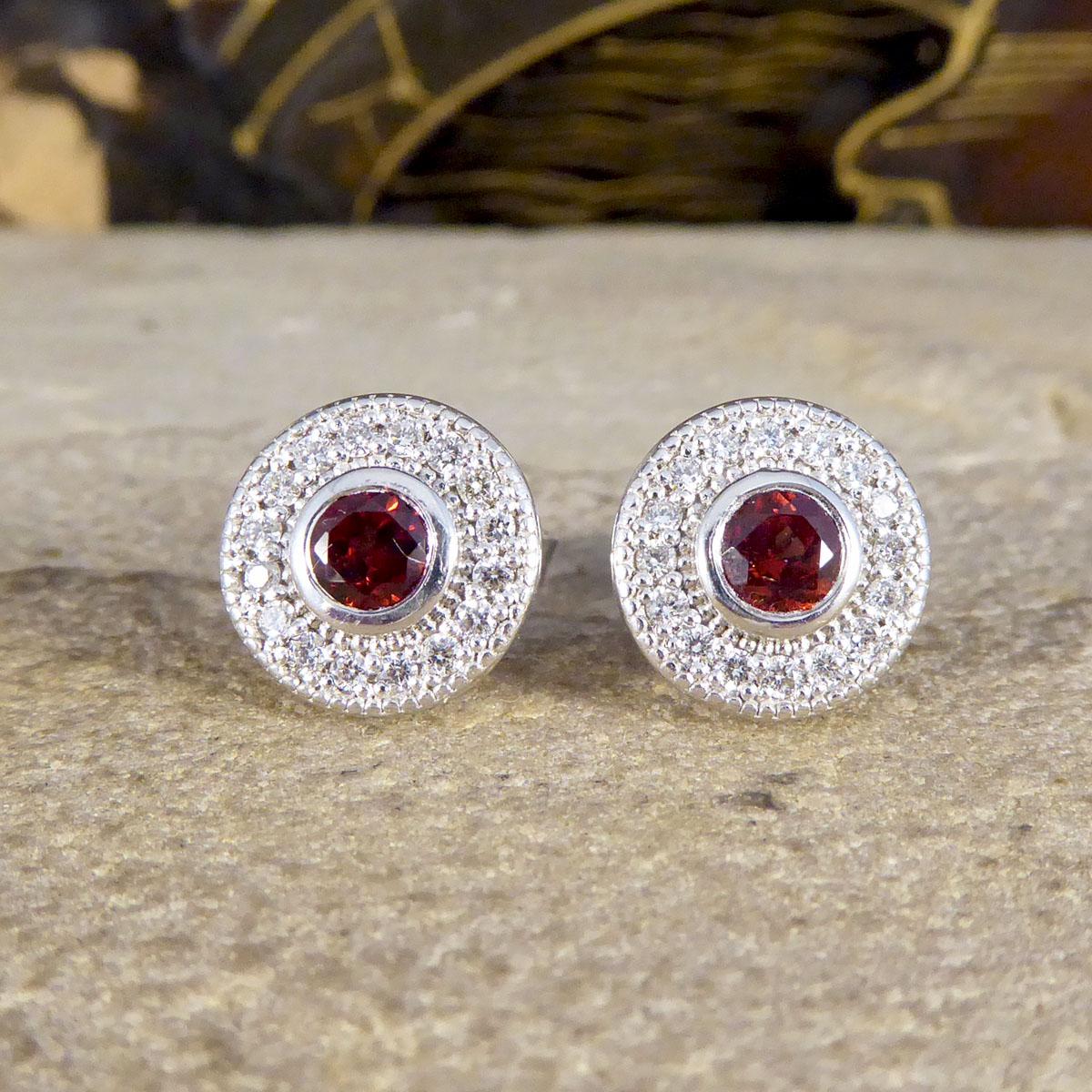 These beautiful contemporary earrings have been made with so much detail in an Art Deco style. Using such a lovely design, the bright red Garnets in the centre of each stud have been set in a cluster form with a Diamond halo surround in a milgrain