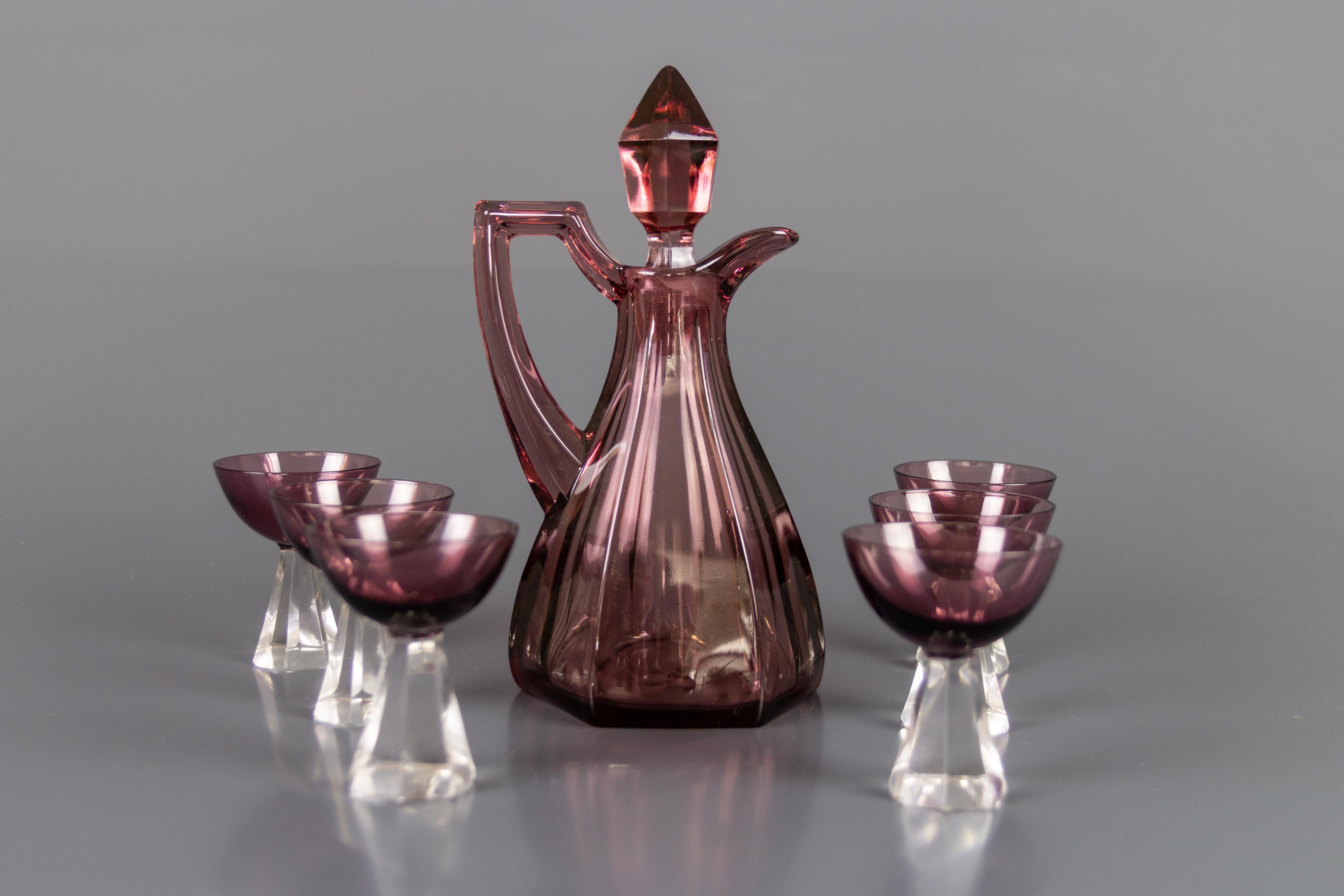 Beautifully shaped mulberry color glass decanter set with 6 glasses, made in the 1950s. The glasses have a transparent base.
Dimensions:
Decanter (including stopper): Height 20 cm / 7.87 in, width 10 cm / 3.93 in, depth 9.5 cm / 3.74 in. Stopper: