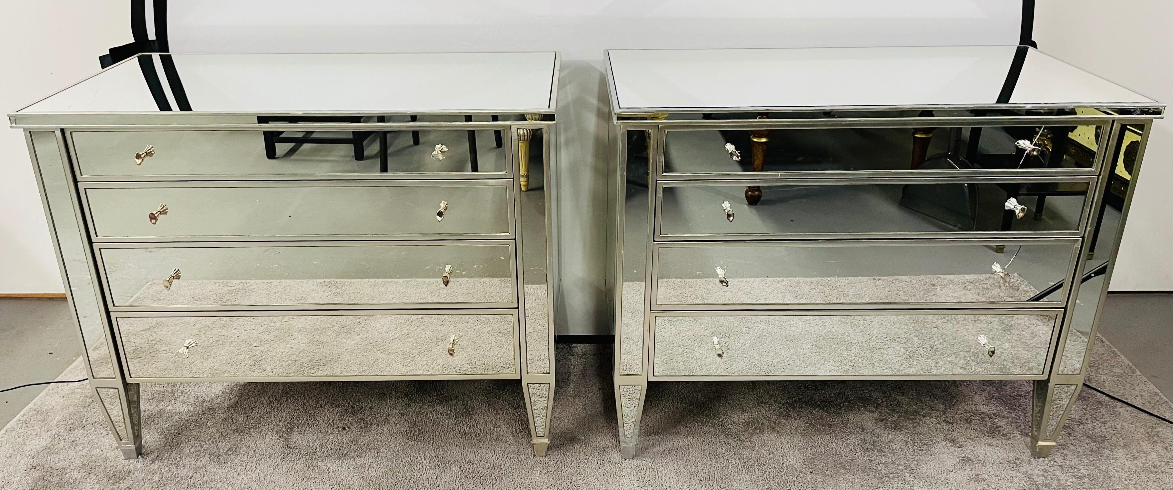 A stunning pair of Art Deco style Nancy Corzine Collette mirrored commodes, nightstands or chests. Each commode has 4 drawers with original silvered knobs and is signed inside the drawer Nancy Corzine. Classy and stylish, these pair of commodes or