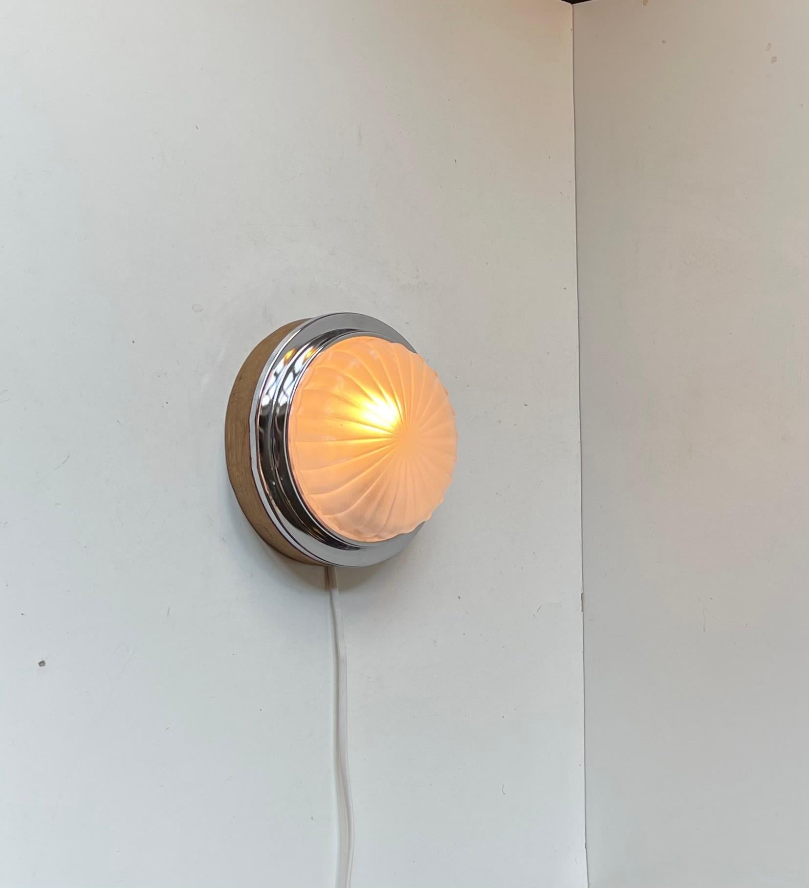 A  Aplique fijo de estilo art déco náutico. Diseñado y fabricado por BMAC en Hyde, Inglaterra, hacia 1960, para un barco estatal inglés del que también procede. Es de metal niquelado/cromado y tiene un motivo de sol en forma de concha en sus