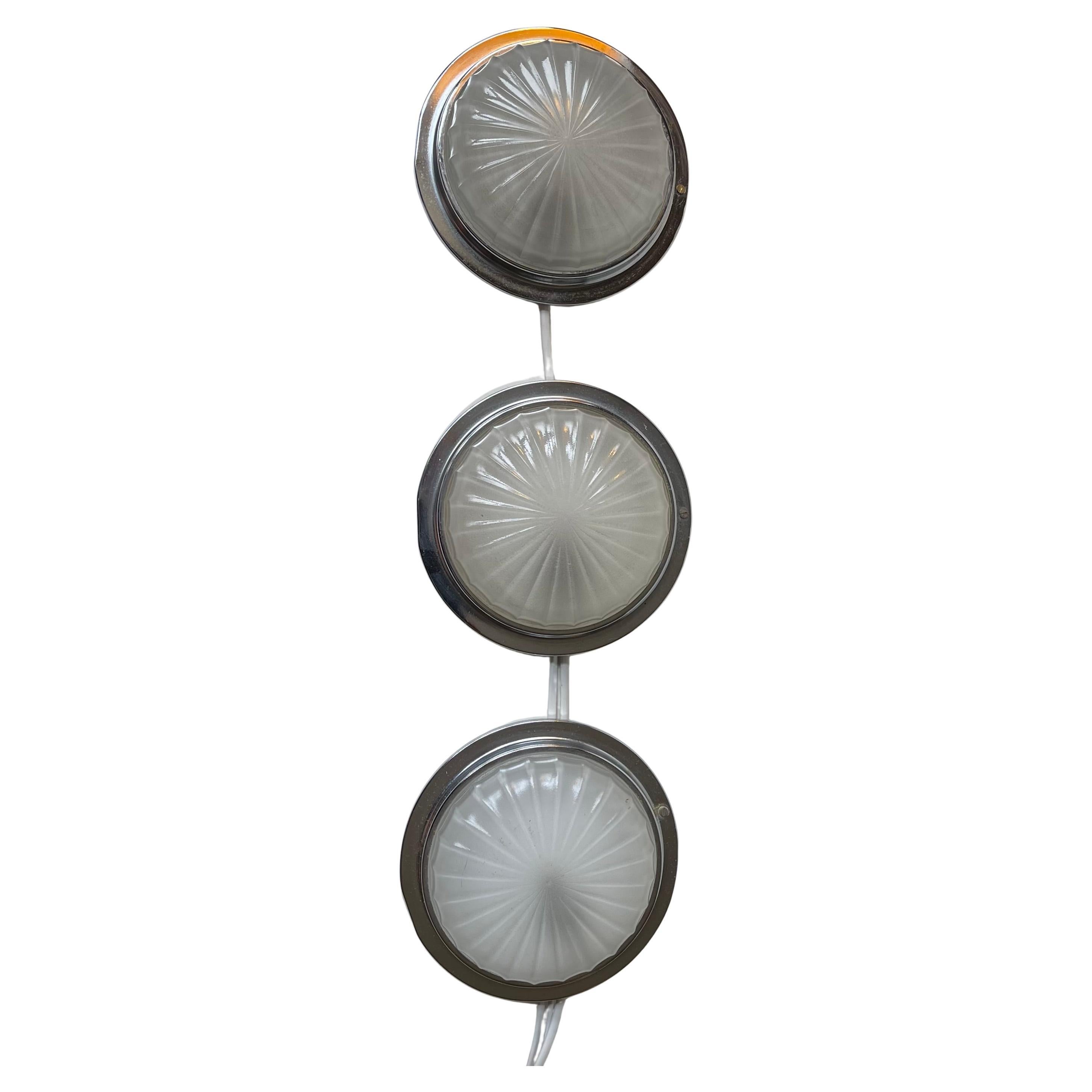 A trio of fixed wall lights in a nautical art deco style. Designed and made by BMAC in Hyde England circa 1960 for an English State Ship where these also came from. The are made of nickel/chrome-plated metal and has a shell like sunburst motif to