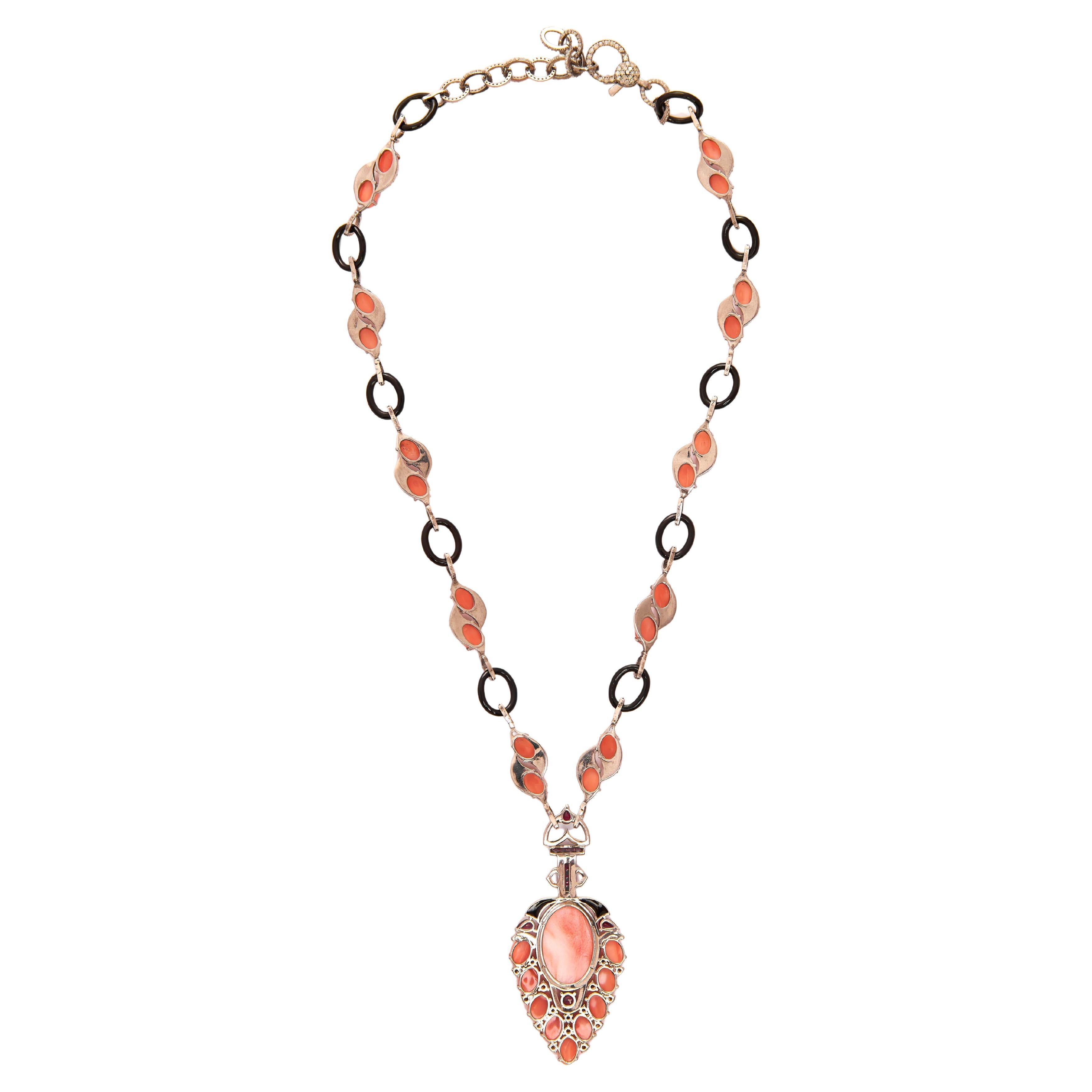 Peso totale-27,650gm, Oro 14KT- 0,780gm, Argento-17,500gm, Diamanti Nature rotondi-1201/5,47cts, Rubino perlato-3/0,79cts, Rubino rotondo-1/0,27cts, Rubino quadrato-8/0,45cts, Onice nero-11/9,95cts, Corallo-29/23,33cts, Corallo-1/6,58cts