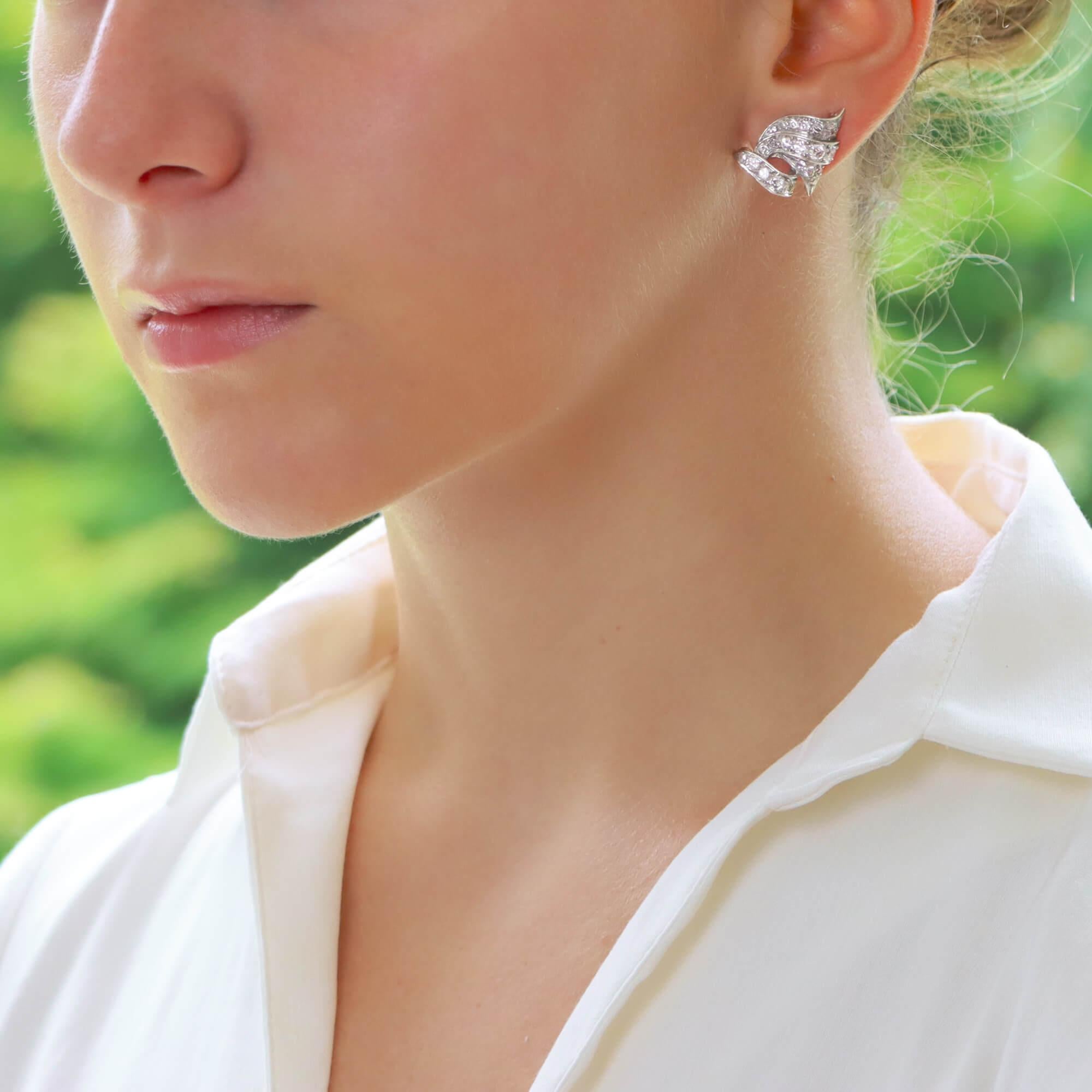 Ein wunderschönes Paar diamantener Ohrringe aus den 1950er Jahren, gefasst in Platin.

Jeder Ohrring zeigt ein zartes, rollenförmiges Design, wobei jeder Teil mit Diamanten im Altminenschliff besetzt ist. Die Ohrringe sind so konzipiert, dass sie