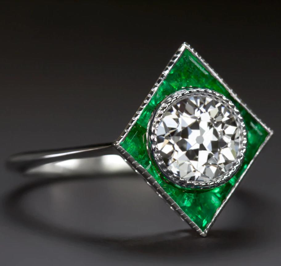 beautifully designed modern twist on an Art Deco era target ring. . The chic geometric setting is set with rich green custom cut natural emeralds. Finished with fine milgrain details, this bezel setting provides the perfect backdrop for a diamond or