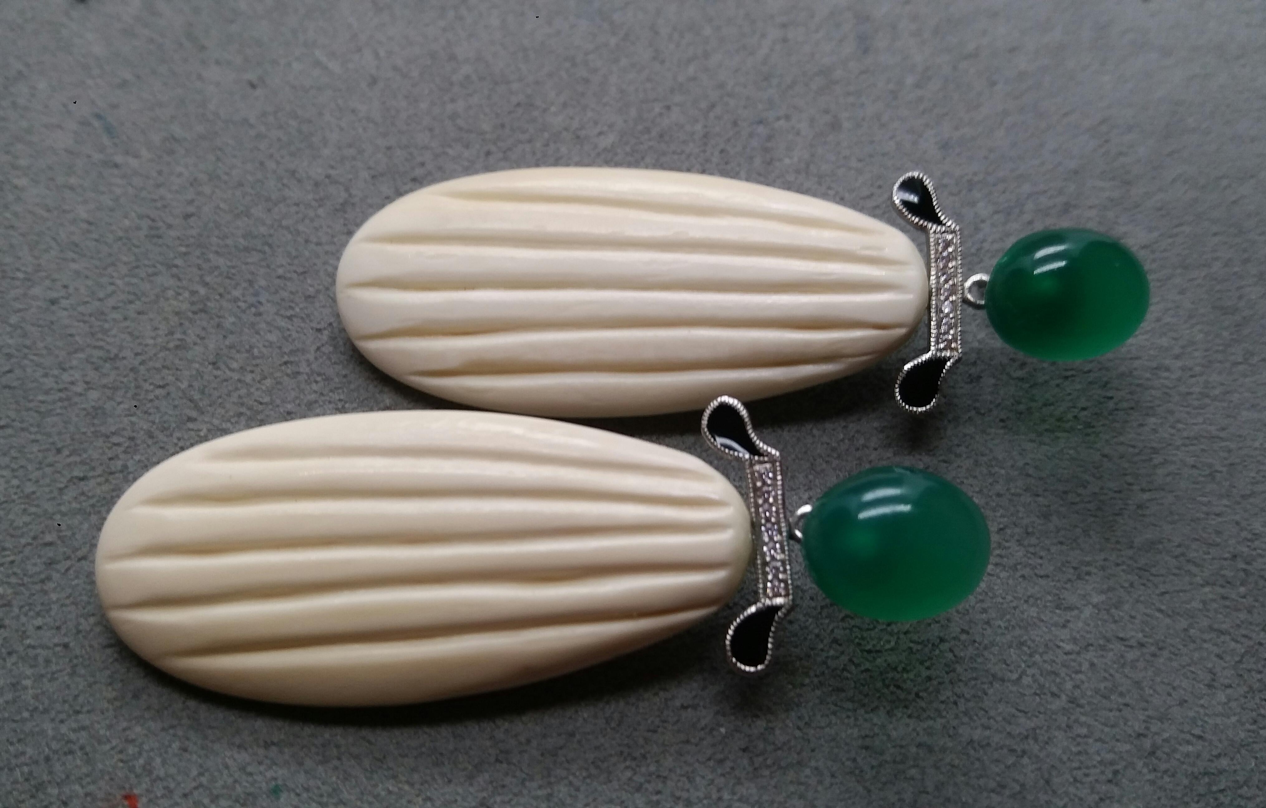 the top has 2 large oval Green Onyx cabochons, then we have a central part in white gold diamonds and black enamel, finally the bottom part is composed of 2 Mammoth bone engraved flat drops

In 1978 our workshop started in Italy to make simple-chic