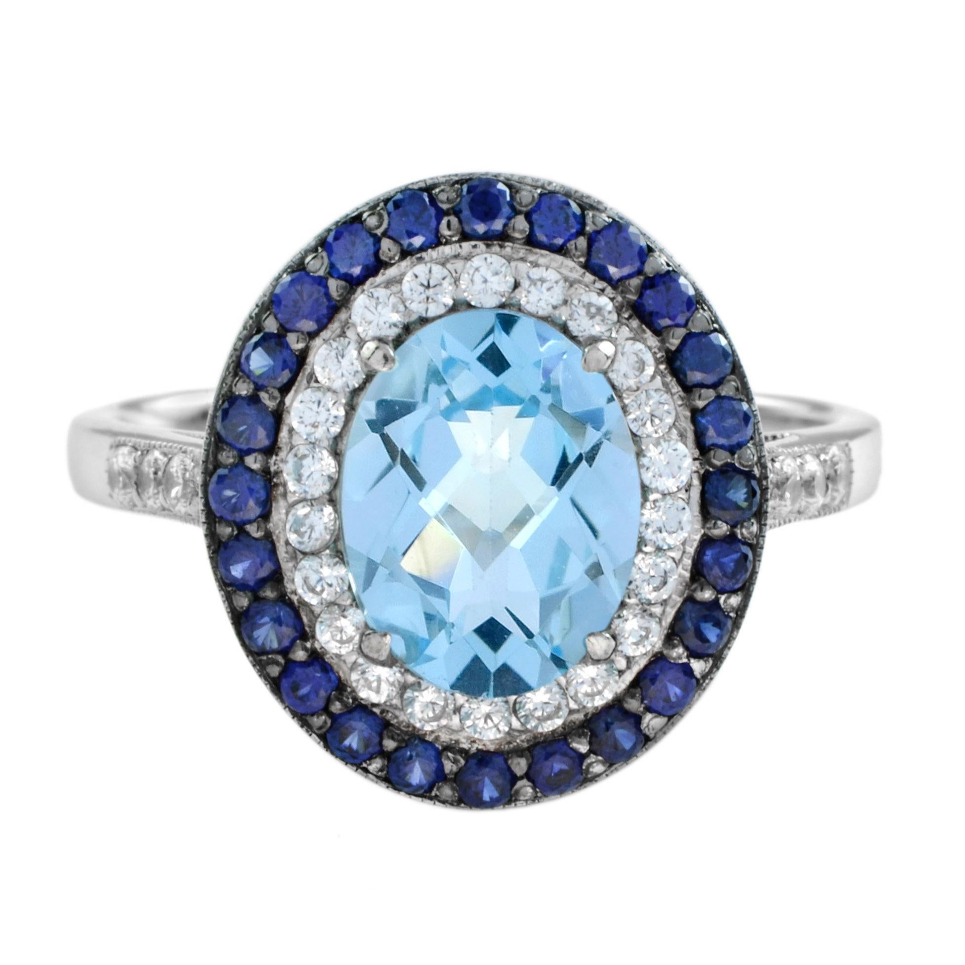 Dieser atemberaubende Halo-Ring funkelt in glänzendem 18k Gold mit schwarzer Rhodium-Beschichtung und verfügt über einen ovalen 9 x 7 blauen Topas Edelsteine in der Mitte mit runden Diamanten und blauen Saphiren in schönen Halo-Designs zusammen mit