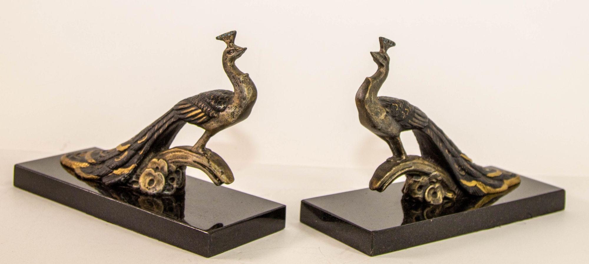 French Art Deco Style Pair Bronze Peacock Bookends on Marble Base.
Hollywood Regency pair of cast metal gilt bronze peacock book ends on black marble base.
Very decorative metal brass peacock standing on a branch.
This is a lovely pair with fine
