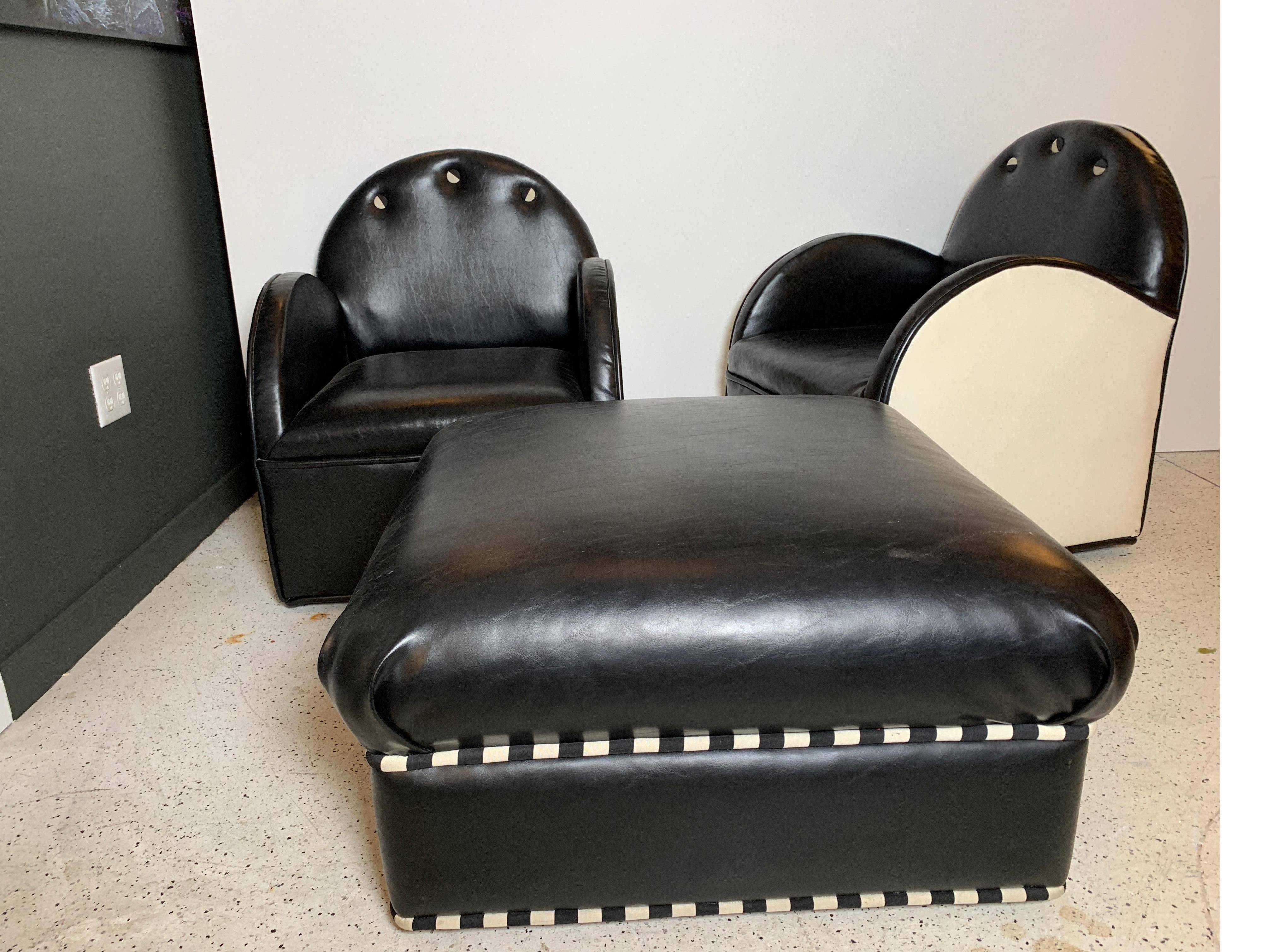 A pair of black and white cub chairs with over sized ottoman. The smaller club chairs with rounded backs and arms paired with a large square ottoman. The ottoman measures 30 inches Square and 17 inches tall. The chairs are 26.5 wide, 32 high, 25