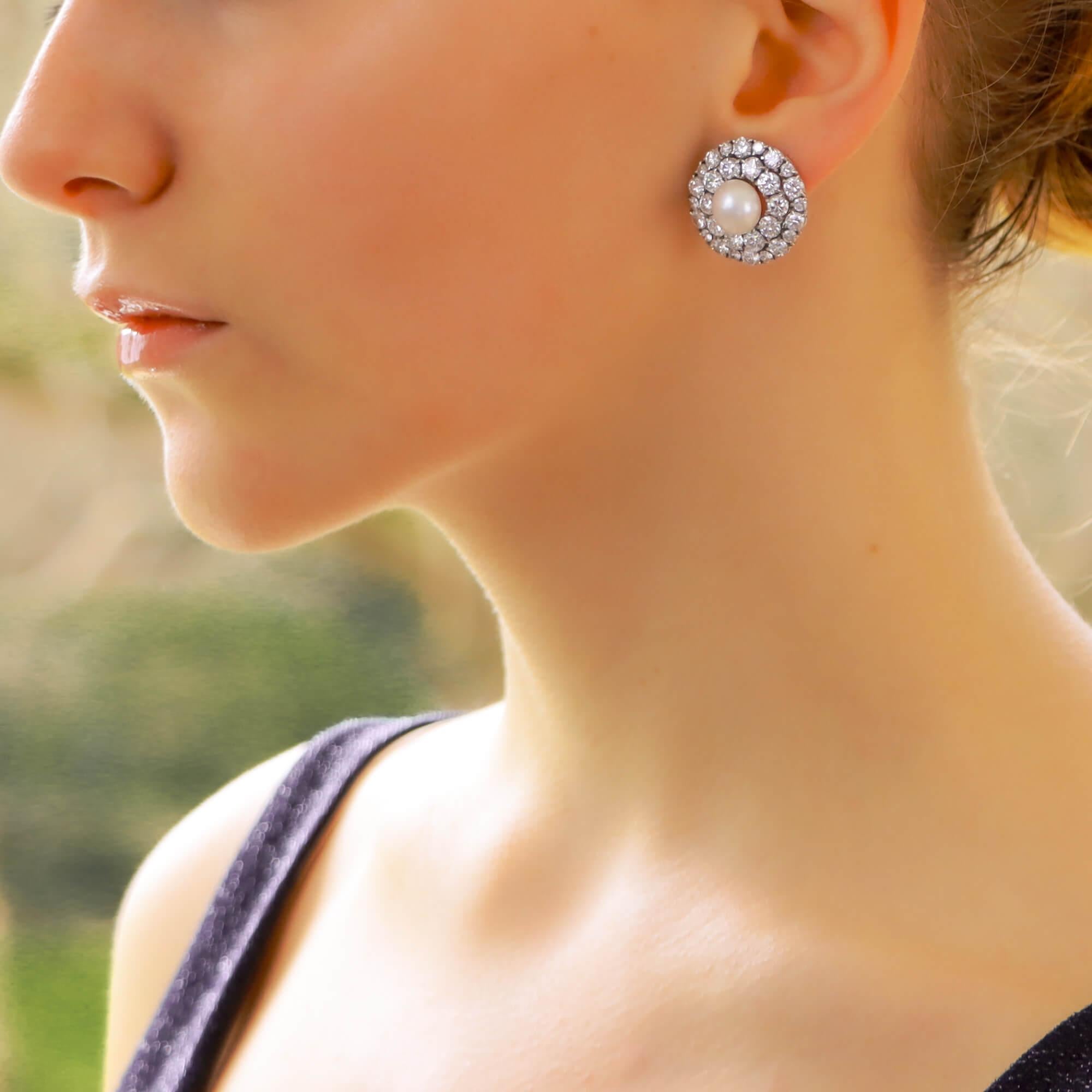 Une très belle paire de boucles d'oreilles de style Art Déco en perles et diamants taille ancienne, montées en or blanc 18 carats.

Chaque boucle d'oreille est sertie au centre d'une superbe perle blanche ronde de 9 x 8 millimètres (soupçonnée