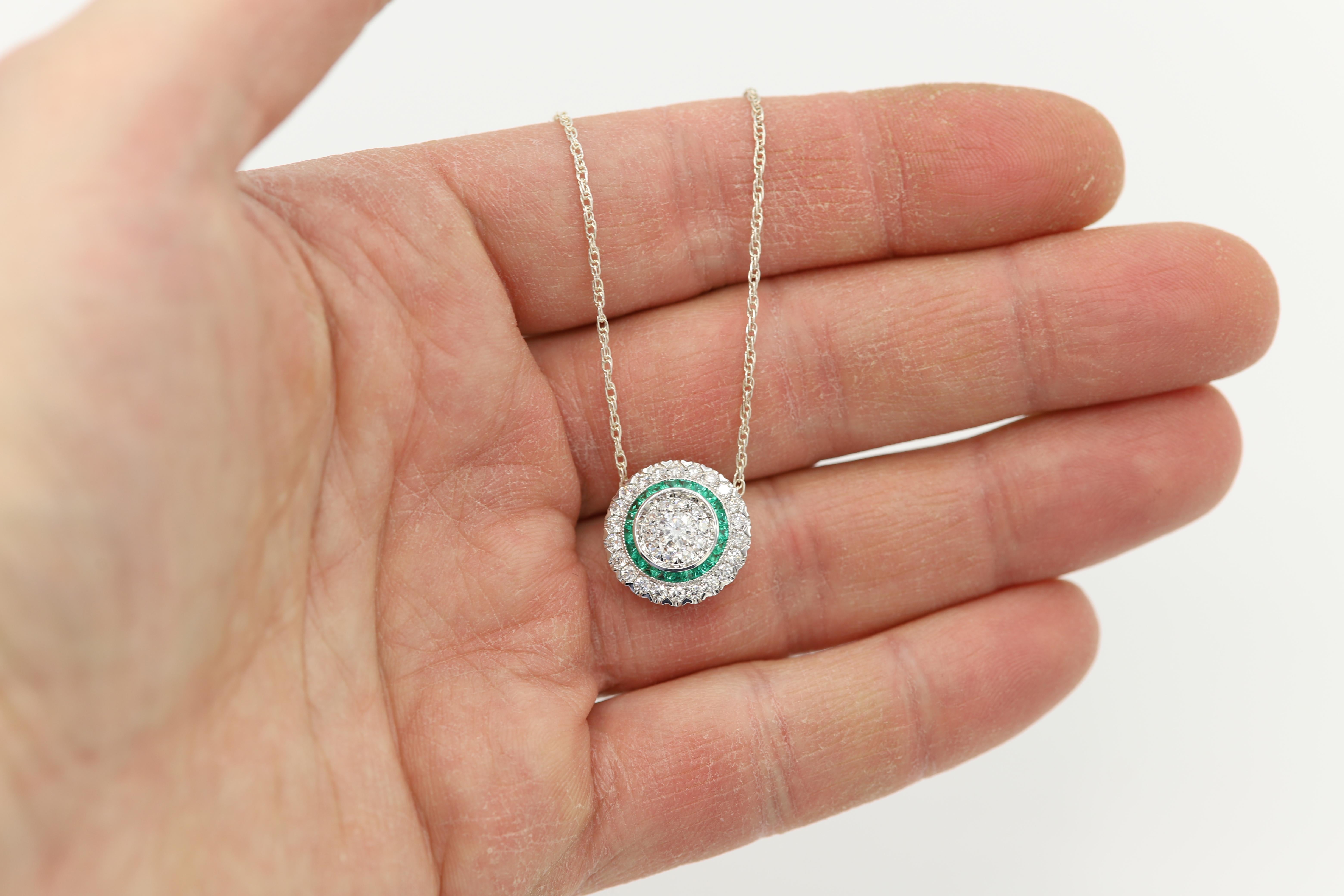 Brilliant Art Deco Style Pendant. 18k White Gold 4.50 grams. Total all Diamonds 0.97 carat (center stones are a super cluster of diamonds that look as a single stone to the eye) GH-SI. Emerald total 0.37 carat.  diameter size approx 17 mm or 5/8