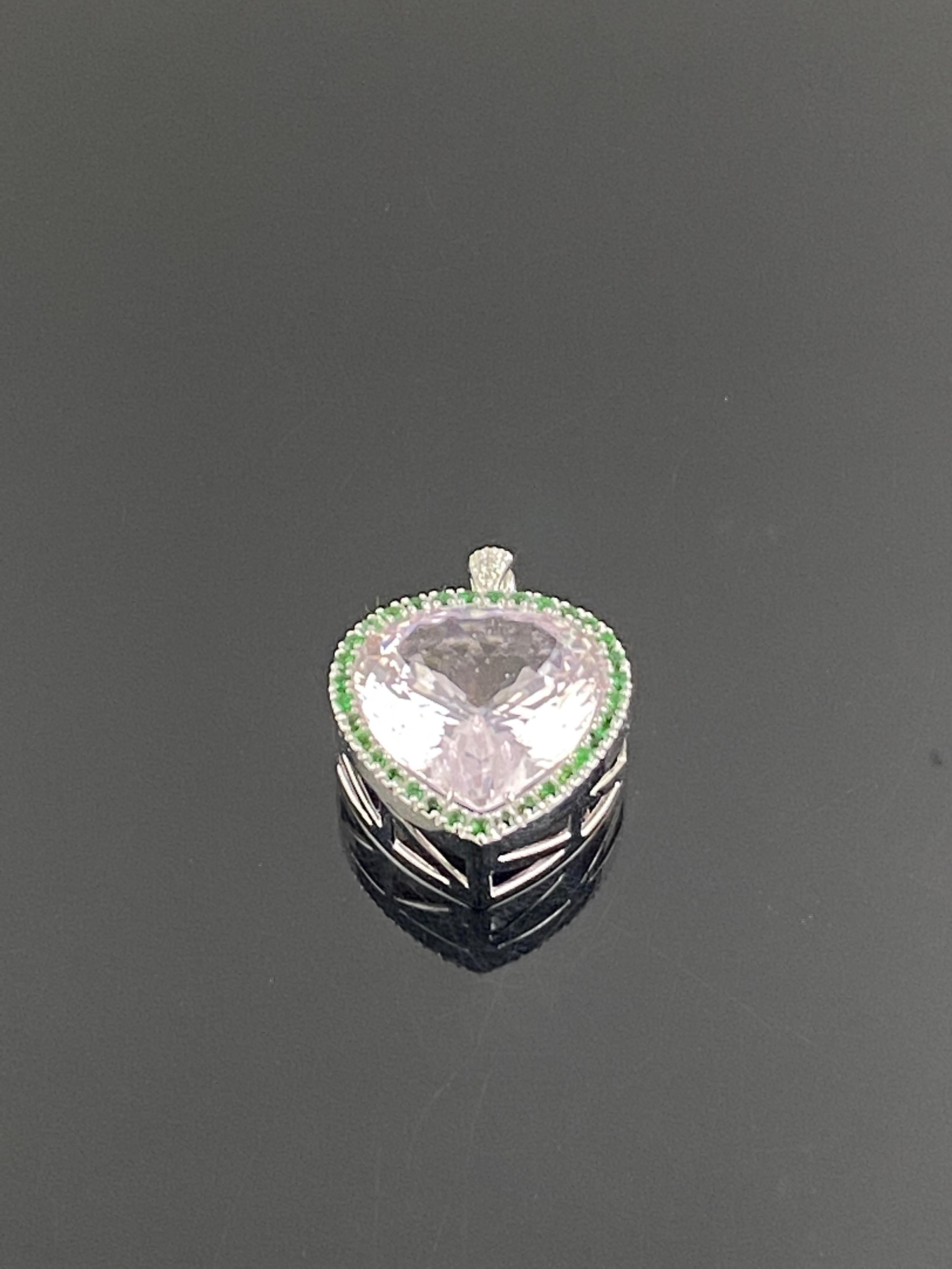 Ce pendentif absolument fabuleux, et unique en son genre, présente une kunzite en forme de coeur plus grande que nature pesant 73.11 carats, sertie de tsavorites (grenats verts) ronds et brillants. Le poids d'or de cette pièce est de 18.72 gms .