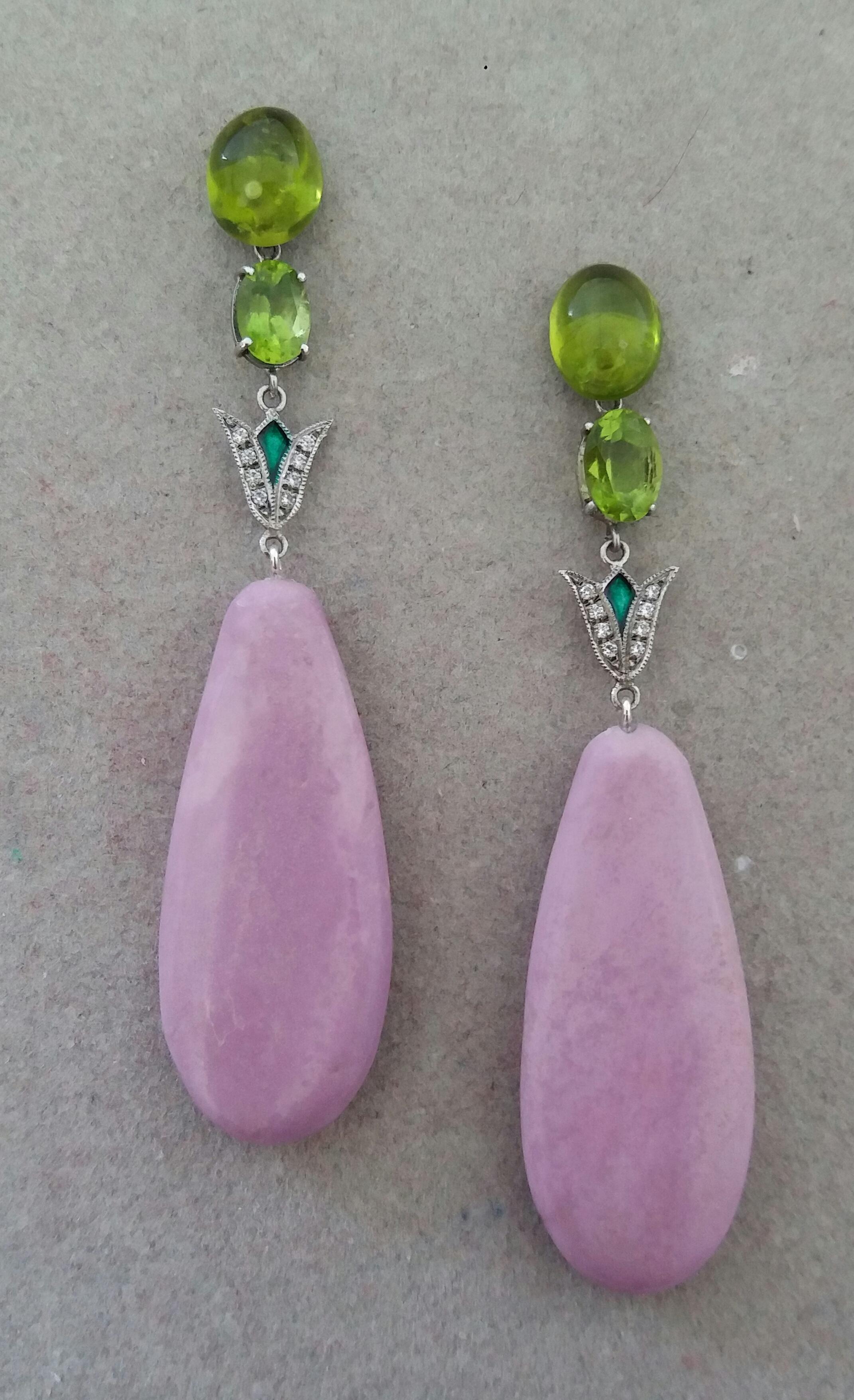 Un paio di orecchini in stile Art Déco, la parte superiore con 2 cabochon ovali di Peridoto 8 mm x 10 mm che sostengono 2 Peridoto ovali sfaccettati 6mmx8mm e 2 elementi in oro bianco, diamanti e smalto verde, mentre le parti inferiori sono composte