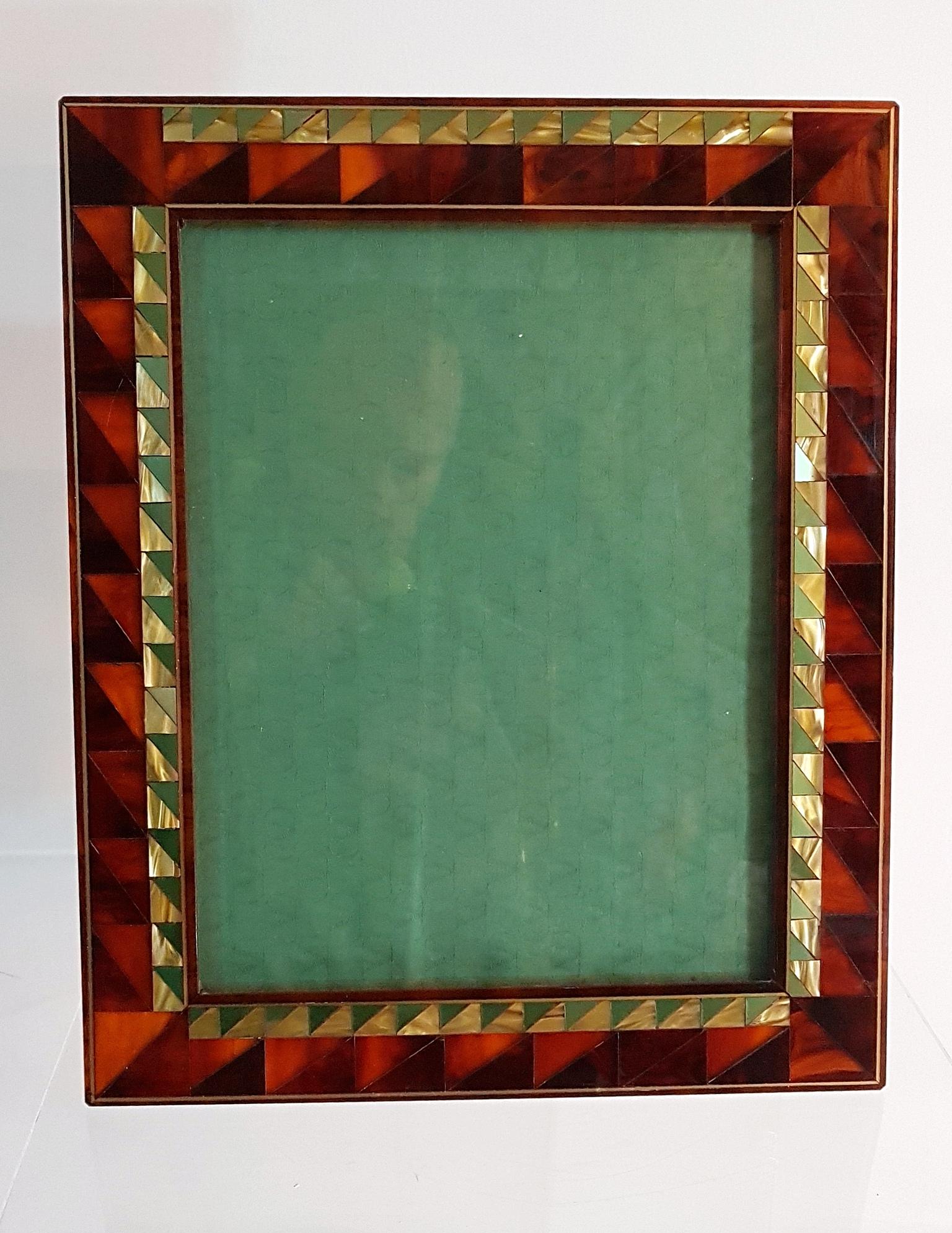 Art Deco style photo/picture frame in tortoiseshell lucite with triangular pattern of mother of pearl. Behind the glass there is a a green fabrick matching the green in the frame with the logo of fashion house of Valentino weaved into the fabric.