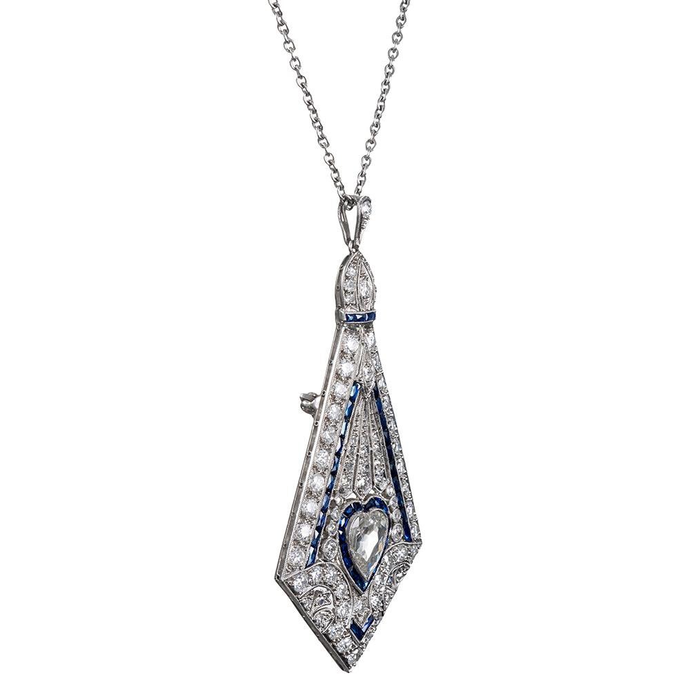 Exquisitely crafted to embody the meticulous creations of the art deco era, this handmade platinum pin/pendant is a celebration of intricate craftsmanship and masterful skill. The piece measures an impressive 2.5 inches long and 1.25 inches wide,