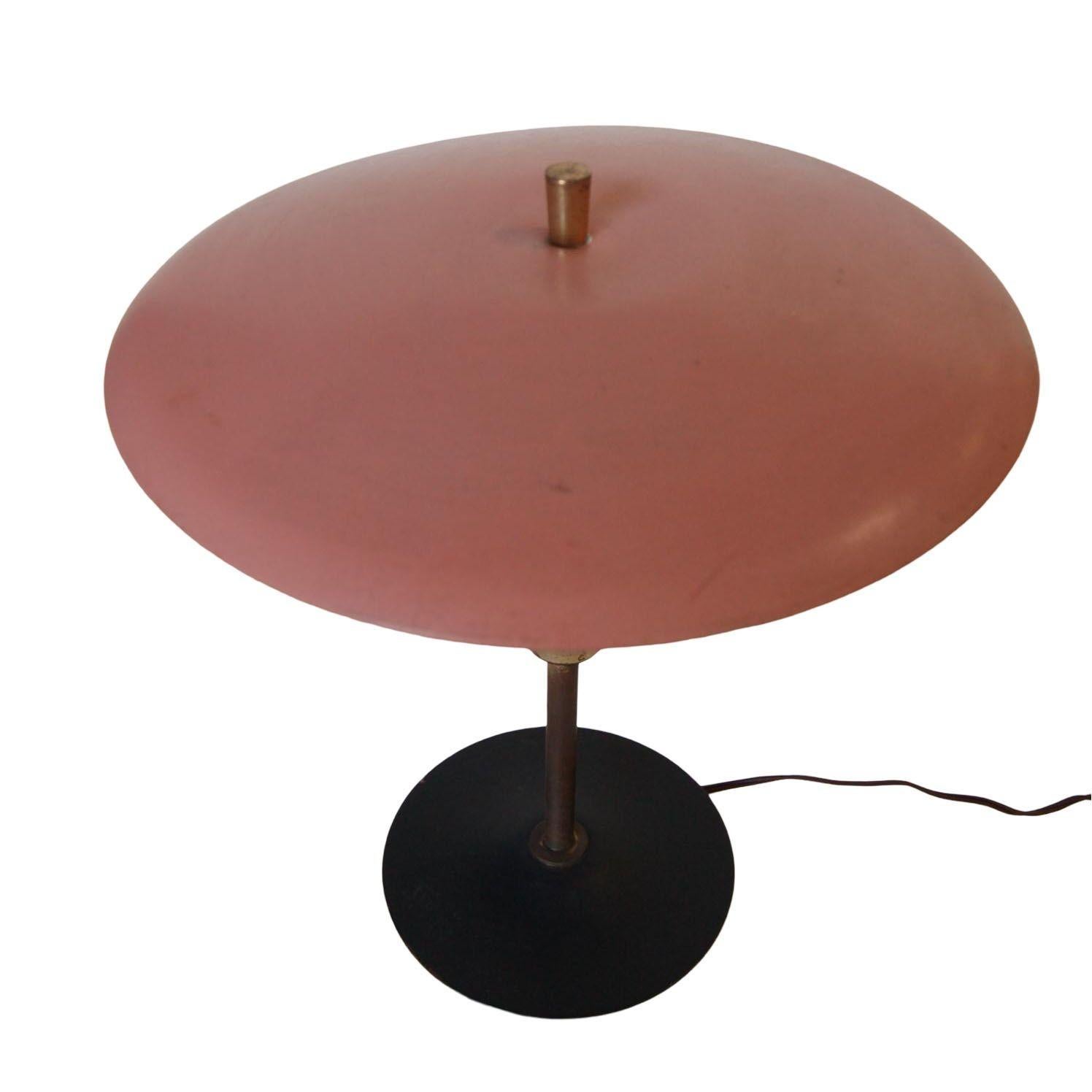 This is an authentic Art Deco style Industrial saucer lamp from the 1960s in original salmon pink color with black and gold trim. This atomic age lamp can be used for home or office. Shade measures: 13