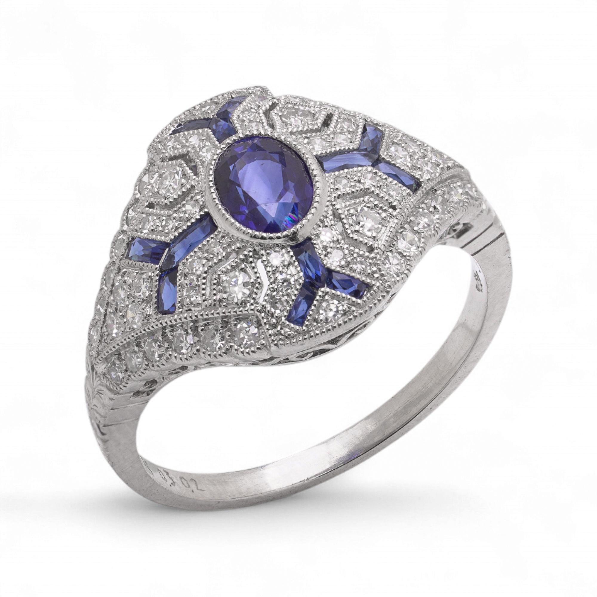 Anello in platino in stile Art Déco con zaffiro ovale centrale sfaccettato del peso di 0,74 carati, incorniciato da zaffiri taglio baguette (0,20 carati) e circondato da 26 diamanti rotondi taglio brillante.

Specifiche
Metallo: Platino
Taglia delle