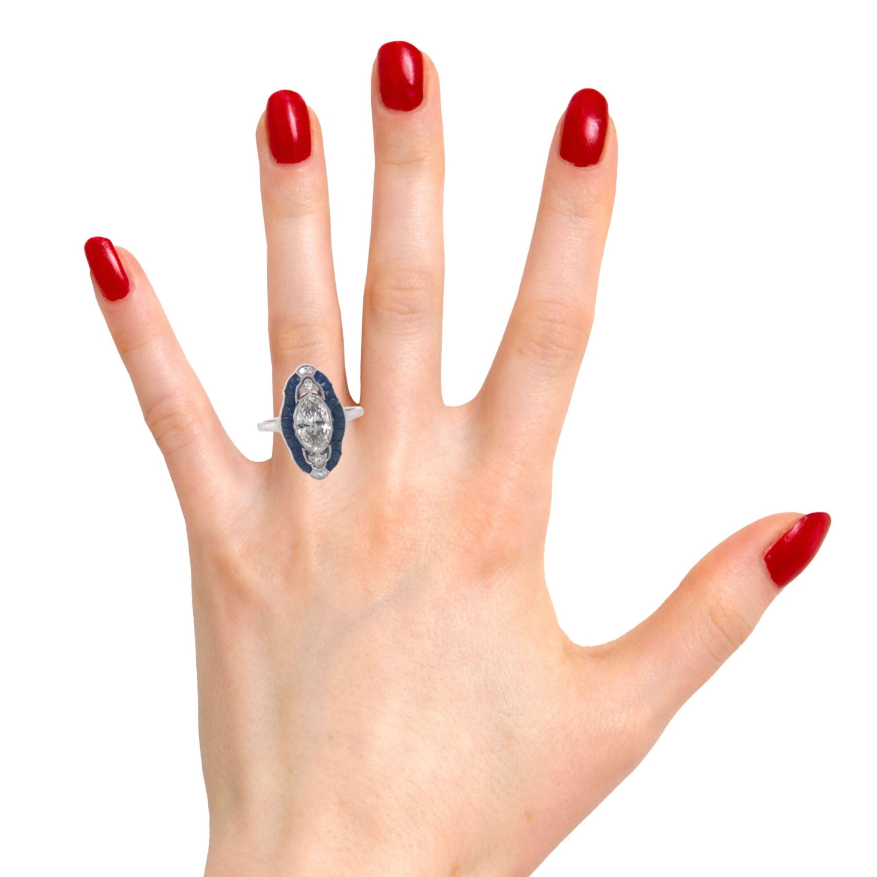Der Ring im Art-déco-Stil mit einem ovalen Diamanten (1,04 CTS GIA F, SI1) und einem Saphir im französischen Schliff strahlt zeitlose Eleganz aus. Das verschlungene Design, charakteristisch für die Art-Déco-Ära, bietet einen einzigartigen und
