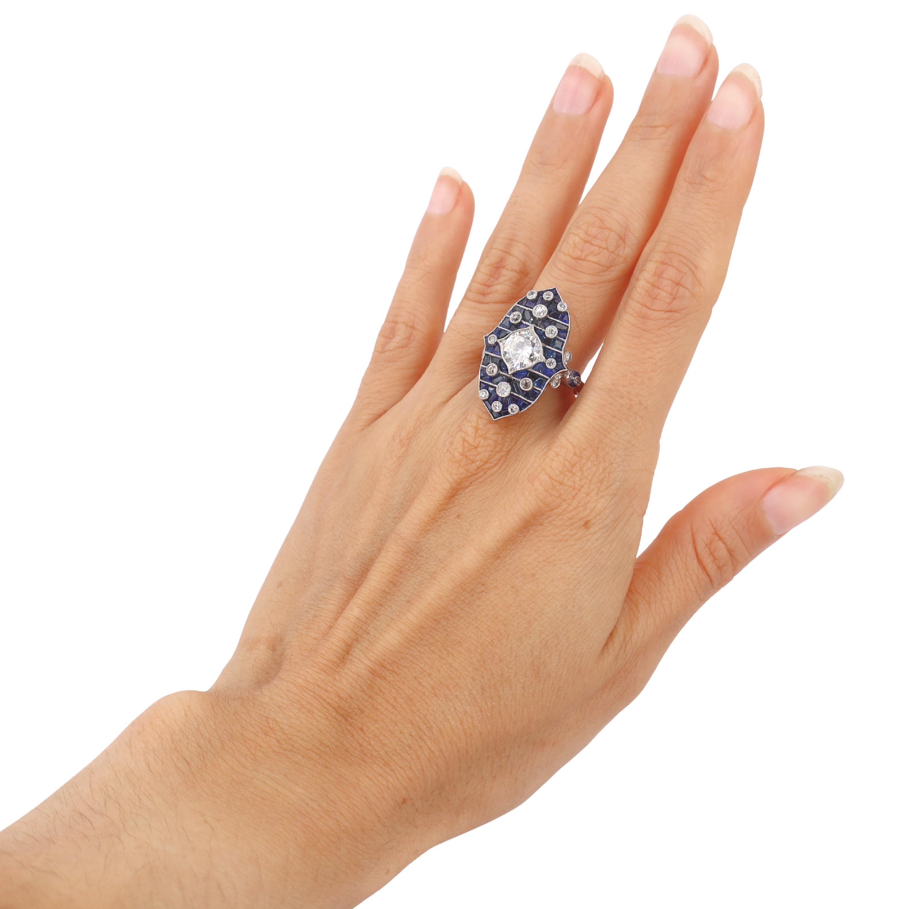 Cette exquise bague de style Art déco illustre l'amour de l'époque pour la précision géométrique et le design audacieux. Elle a été fabriquée de manière experte en platine lustré et présente un magnifique diamant rond de 1,40 carat de couleur J et