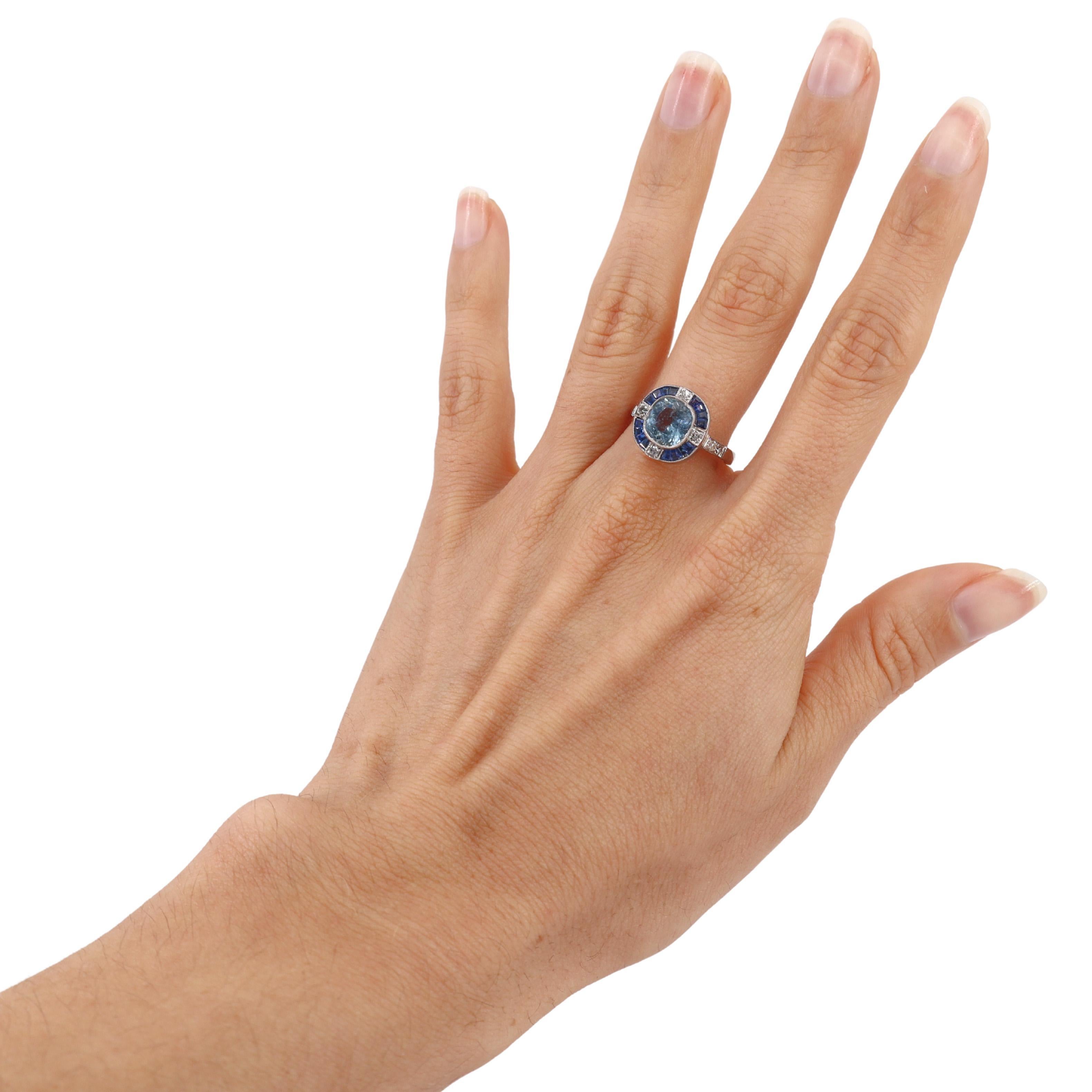 Laissez-vous séduire par l'élégance de cette exquise bague de style Art déco, réalisée en platine. En son centre se trouve une superbe aigue-marine taillée en coussin pesant environ 2,00 carats, d'une teinte bleue sereine qui capture l'essence de la